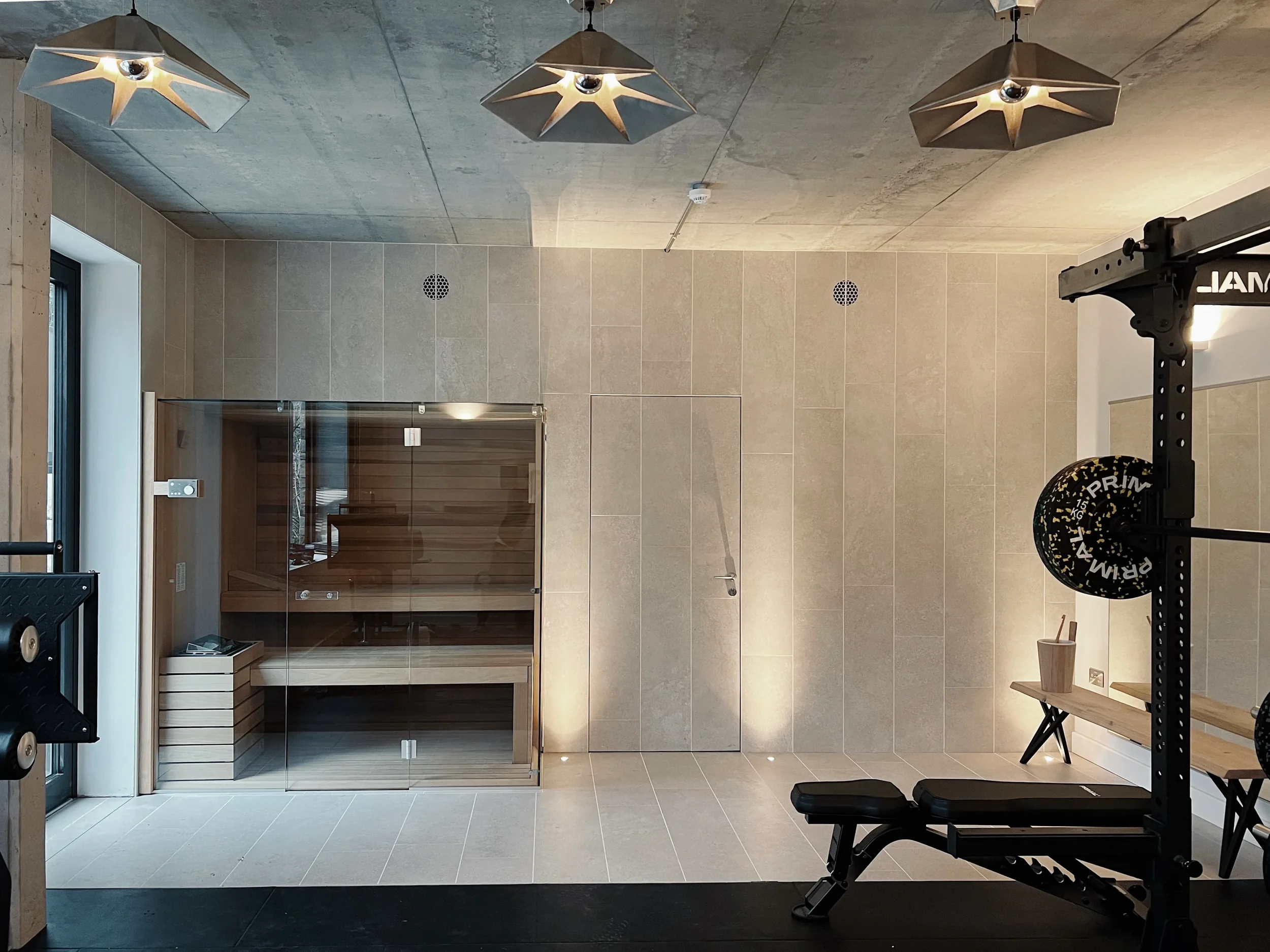 Luxury home gym and spa with stone-look porcelain wall cladding and a hidden door.