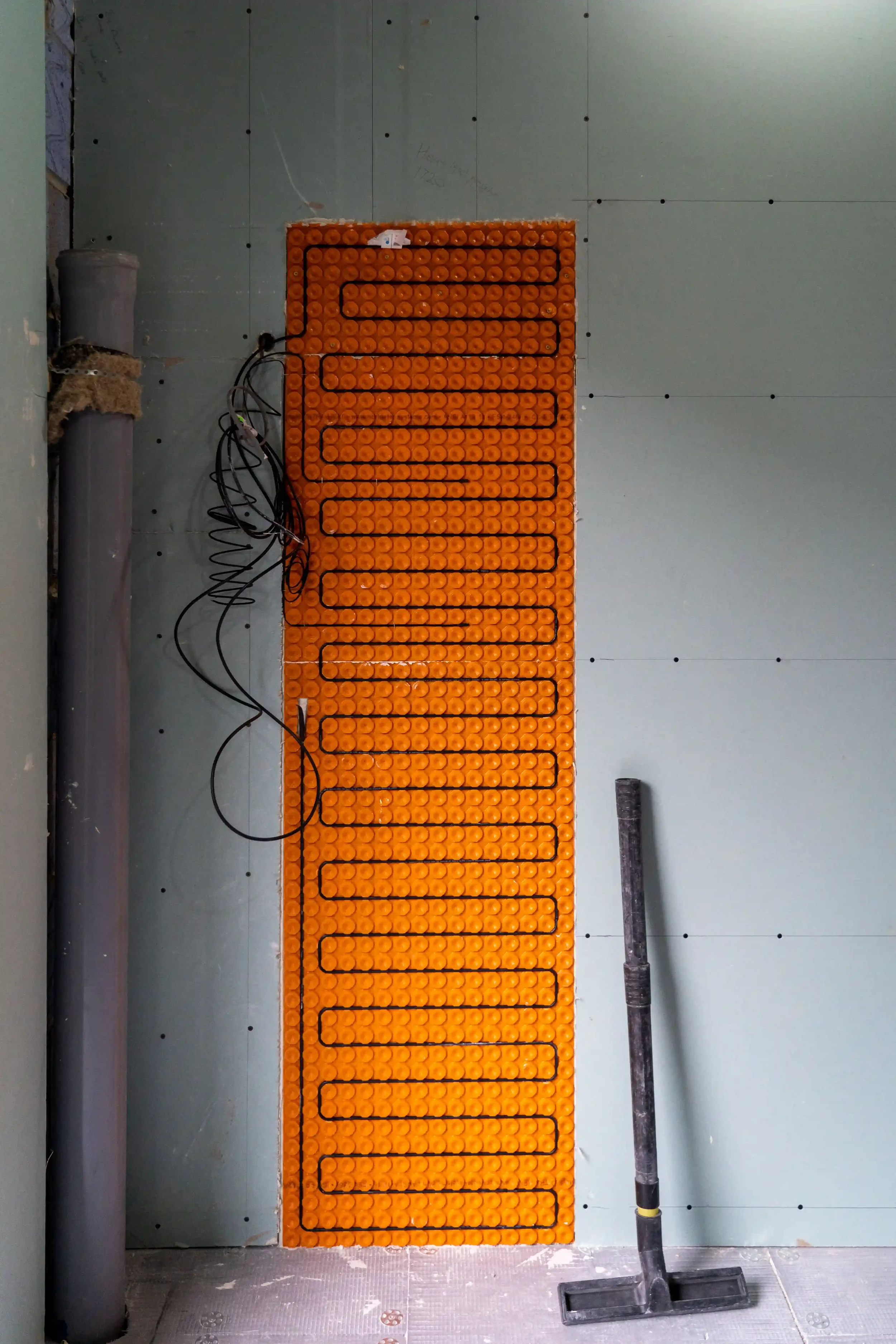 Electric heating system installed on a wall using the orange Schlüter-DITRA-HEAT uncoupling membrane, supplied by PietraCasa.