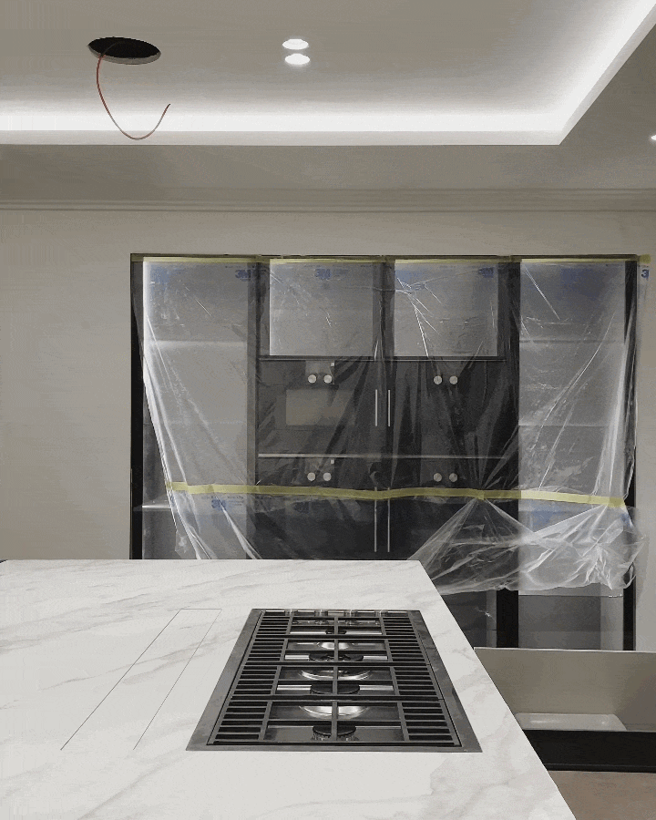 A sleek, modern kitchen installation featuring a marble-effect porcelain island with an integrated downdraft extraction system, showcasing premium finishes and contemporary design.