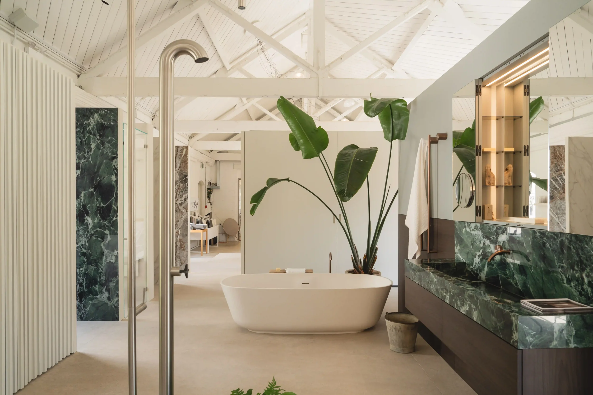 Bespoke Makro integrated sink and vanity custom fabricated from green marble-look porcelain slabs with an overhead mirror cabinet.