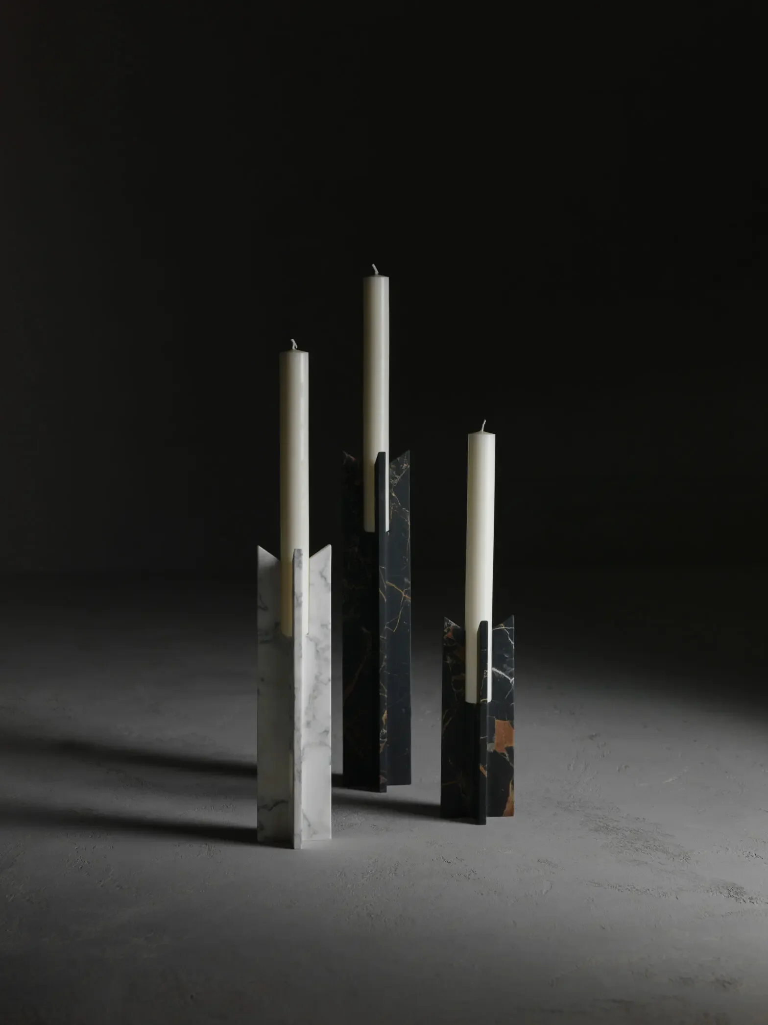 The Trinity candlesticks designed by Christophe Pillet for Kreoo, hand-carved from a single block of marble with a distinctive cross-shaped structure, available through PietraCasa.