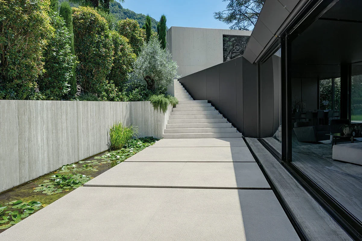 A modern outdoor space featuring premium Kronos Ceramiche Terra Crea porcelain tiles, designed to create a seamless transition between indoor and outdoor areas, available through PietraCasa.