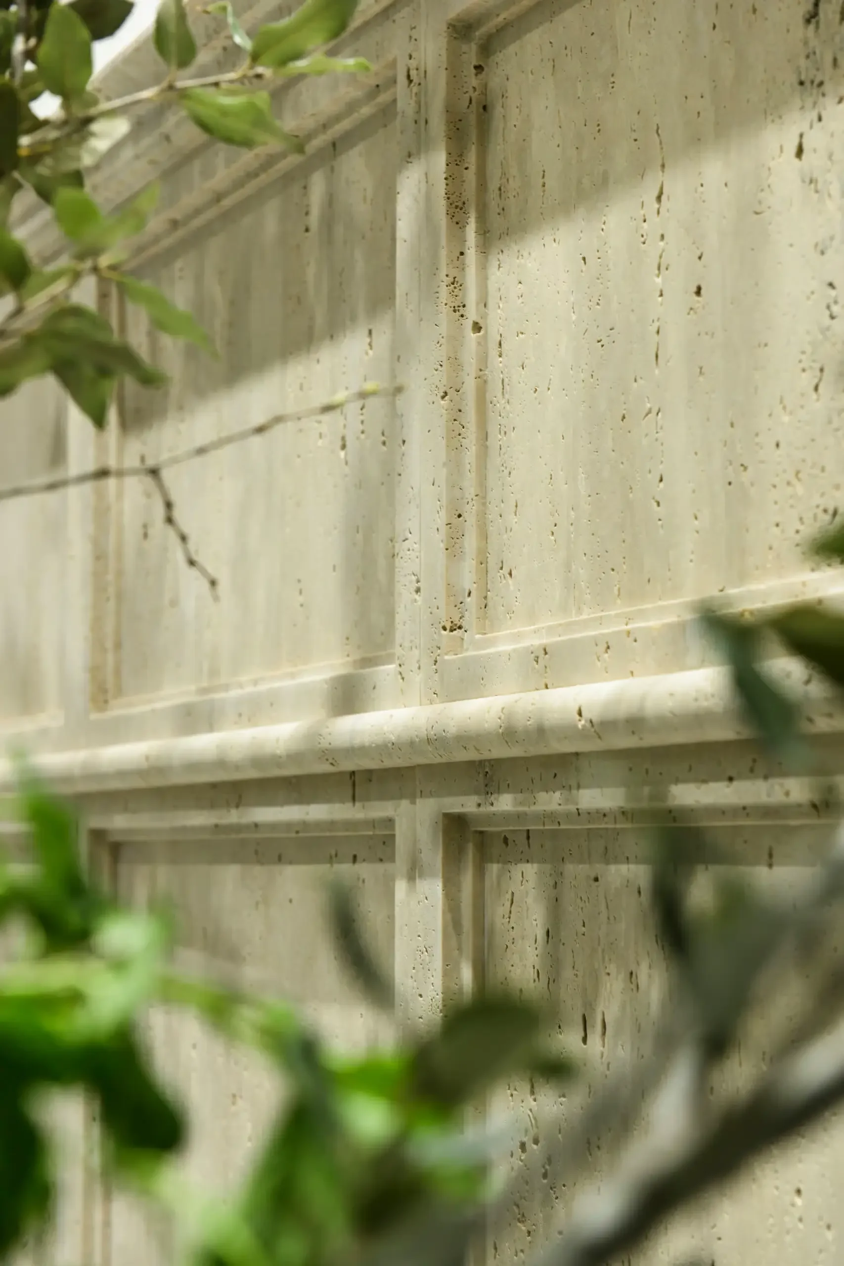 The Kreoo Prestige Boiserie, an innovative wall covering designed by Christophe Pillet, featuring classic Haussmann-style moldings and raised panels meticulously carved into natural Travertine marble, available through PietraCasa.
