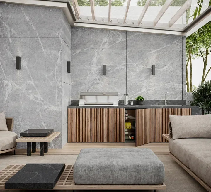 Elegant outdoor living and patio kitchen area featuring premium Antolini natural stone wall slabs with striking white veining on a soft grey backdrop, supplied by PietraCasa.