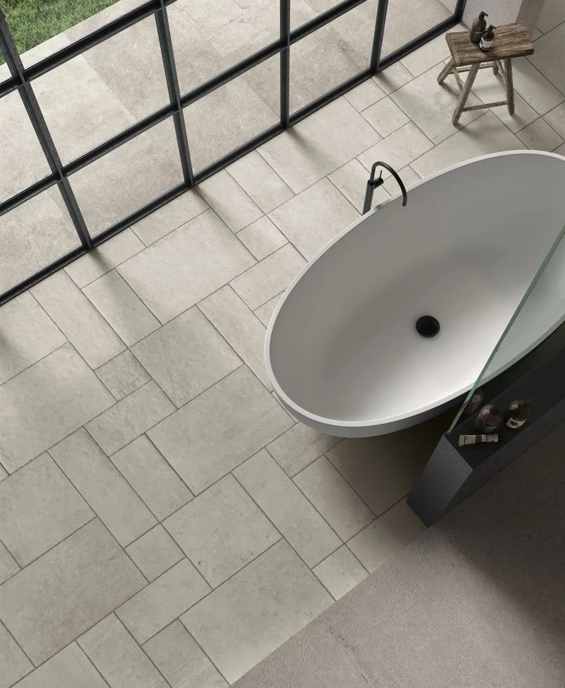 Bathroom flooring featuring the Le Reverse collection by Kronos Ceramiche in the Opal colorway, showcasing a distinctive 'Crafted Edge' finish that mimics the texture of aged stone, available through PietraCasa.