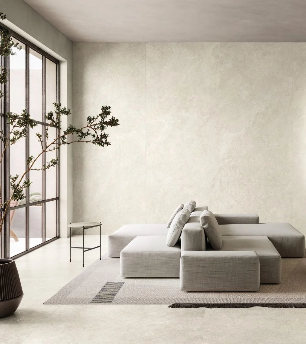 Sophisticated living room featuring Limestone White porcelain slabs by Impronta, a premium Italgraniti Group brand, creating a bright and modern atmosphere, supplied and installed by PietraCasa.