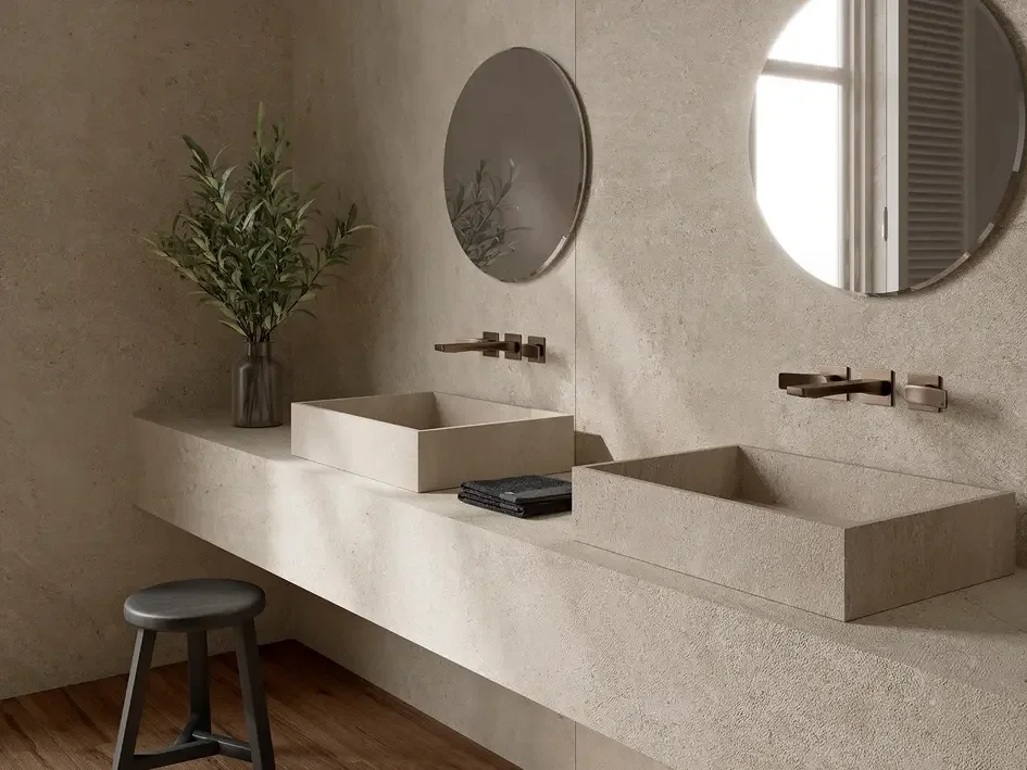 Sleek double bathroom vanity featuring bespoke countertop basins and a monolithic countertop in Inalco’s Petra Crema, an antibacterial, micro-textured mineral surface, exclusively distributed in the UK by PietraCasa.