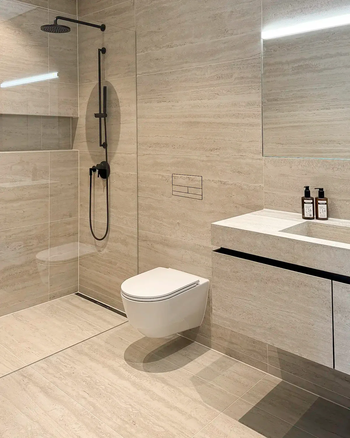 Luxury bathroom featuring a Clanea PurePlate, a tileable toilet flush cover designed to blend seamlessly into the wall tiles, supplied and installed by PietraCasa.