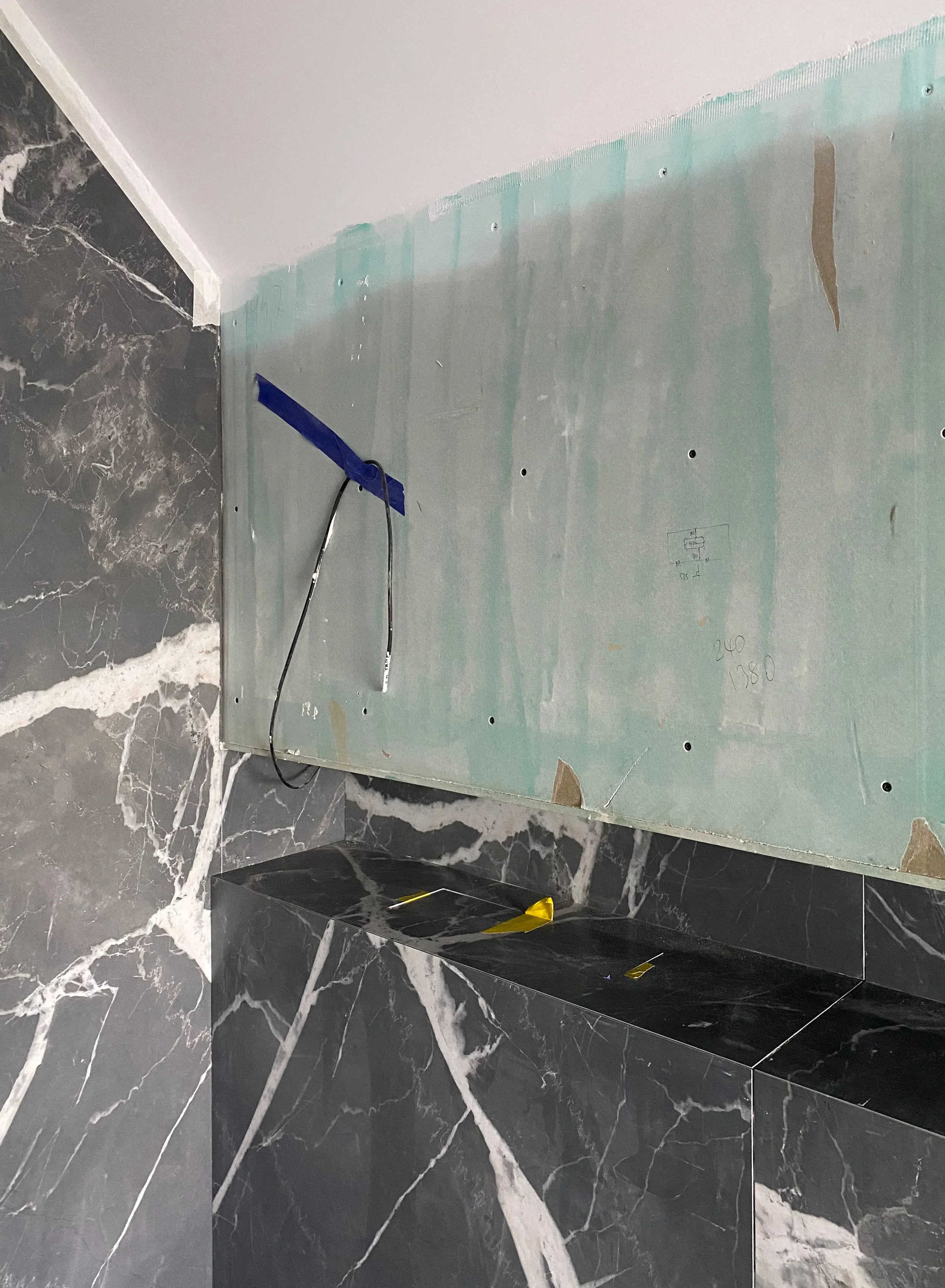 Large-format dark marble-look porcelain bathroom wall tiles by PietraCasa.