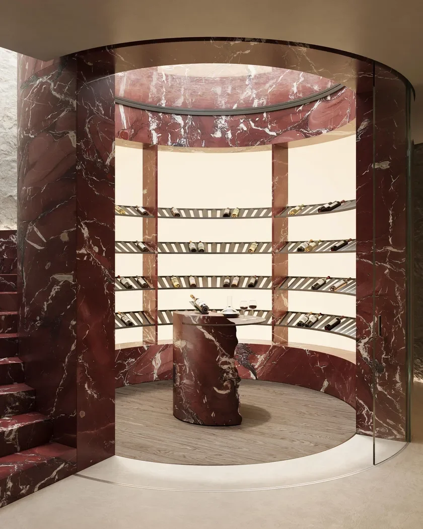 Elegant circular wine cellar installation featuring Rosso Cardinale marble by Margraf, with bespoke shelving and stone detailing, supplied by PietraCasa.