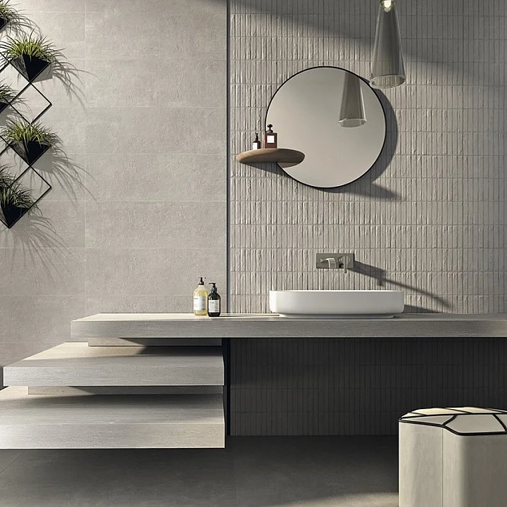 A modern bathroom design featuring a sophisticated combination of smooth and tactile, ribbed porcelain stoneware surfaces by Fiandre, expertly supplied and installed by PietraCasa.