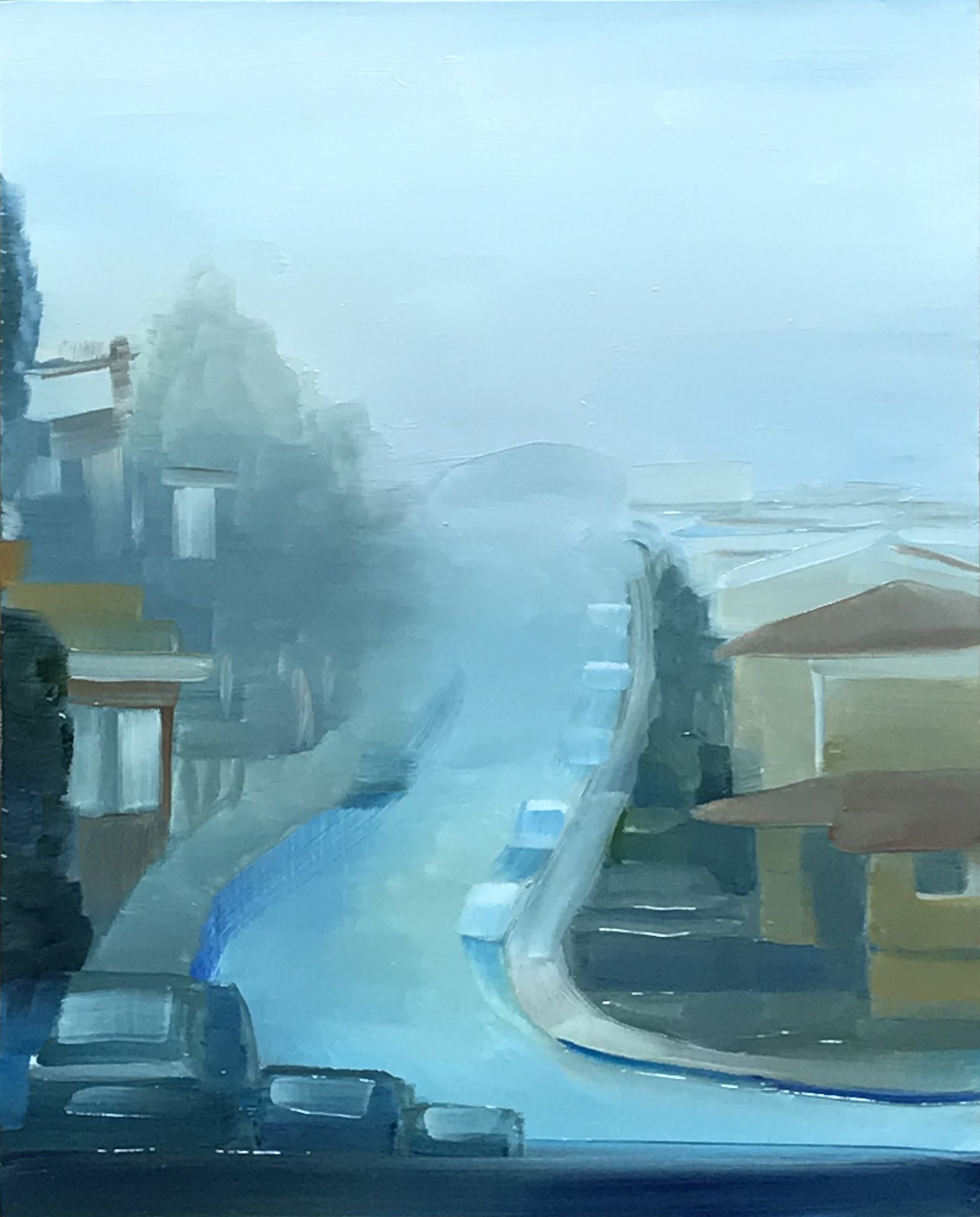 A view of a curvy and steep San Francisco city street shrouded in fog.