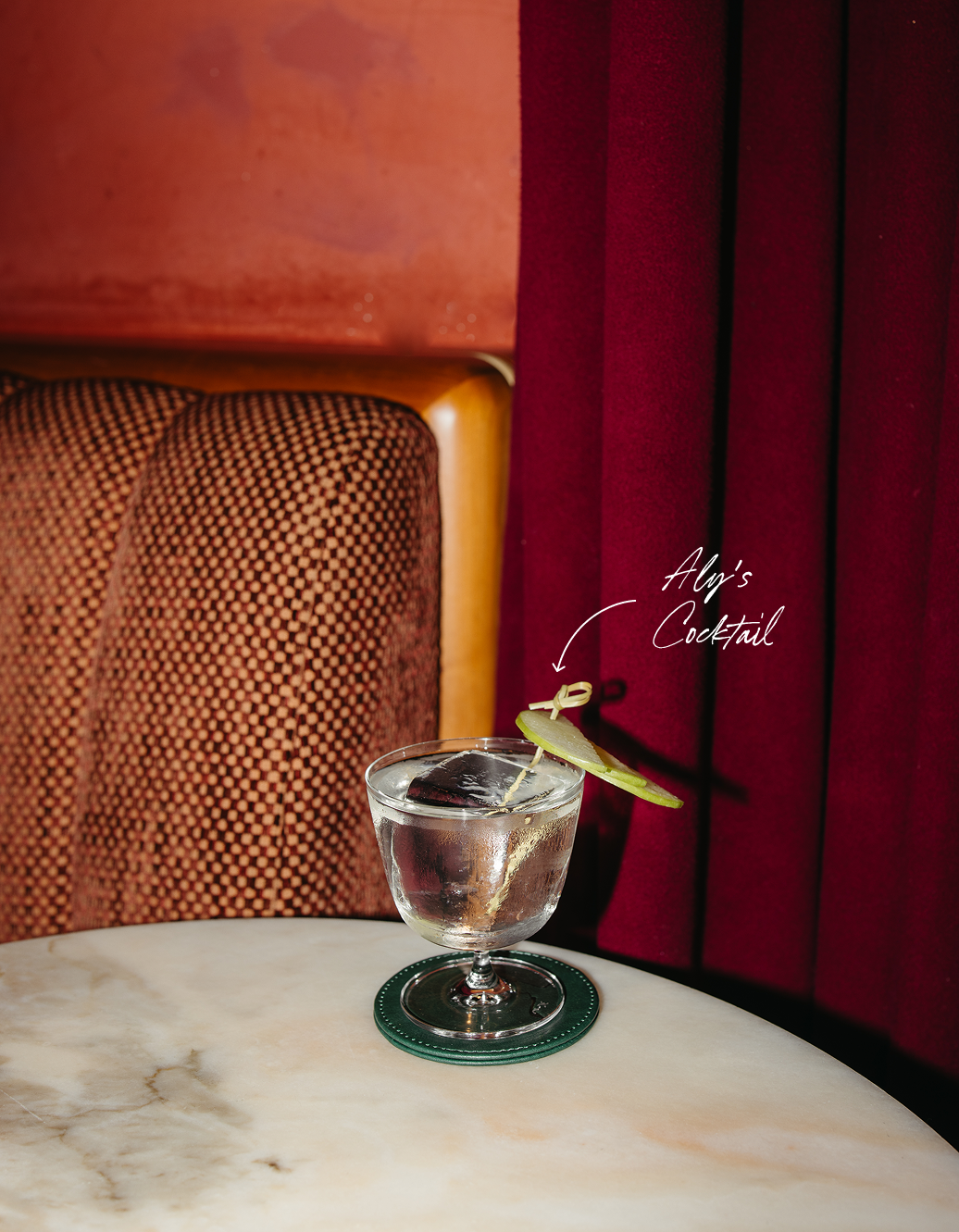 Aly's cocktail — a drink with a lime wedge garnish and straw