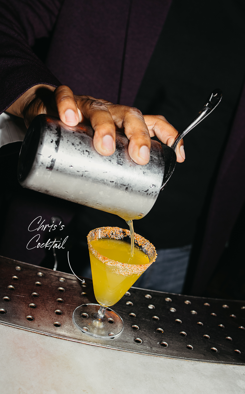Chris's cocktail being poured from a shaker into a salted rim glass
