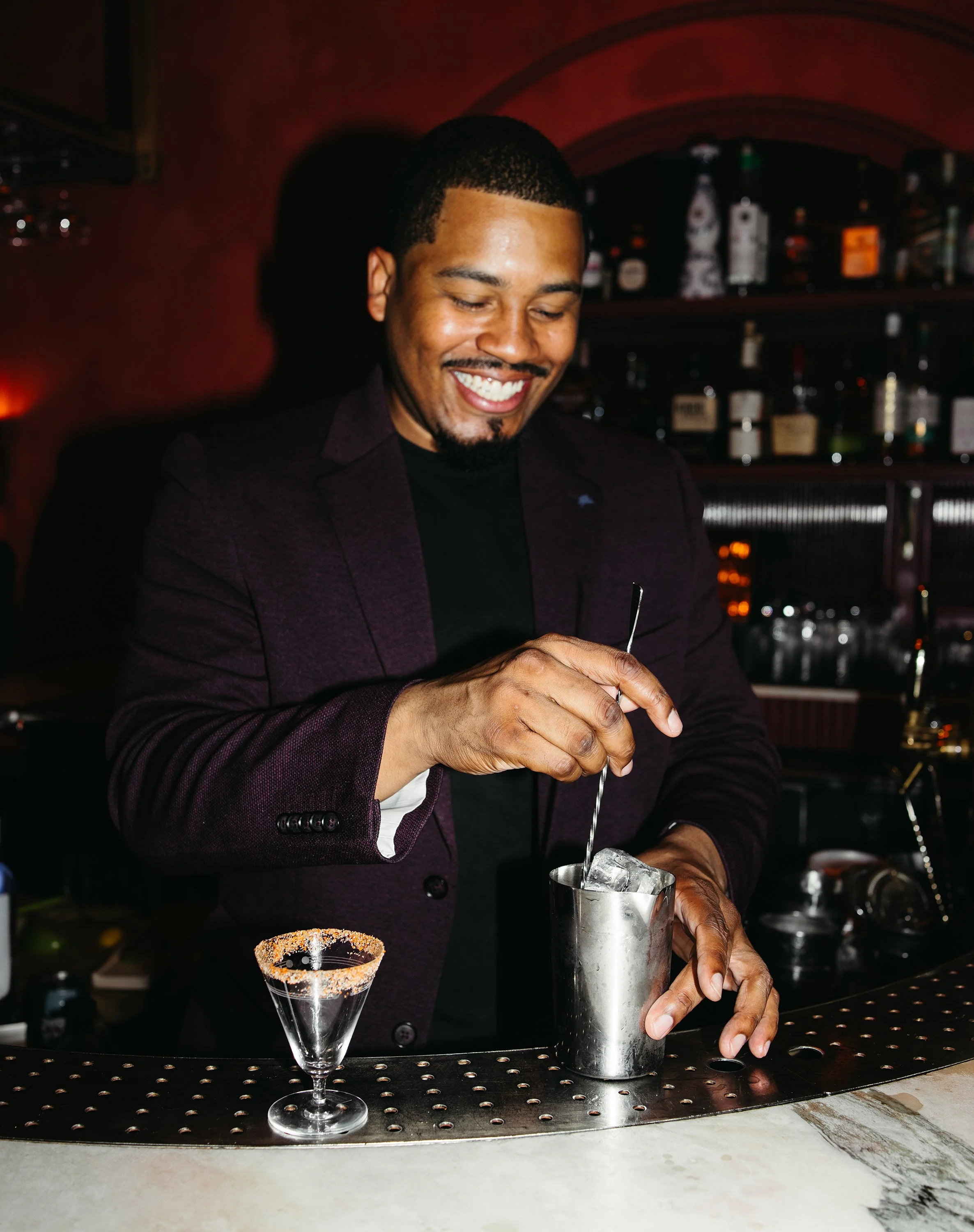 Chris Figueroa preparing a cocktail behind the bar