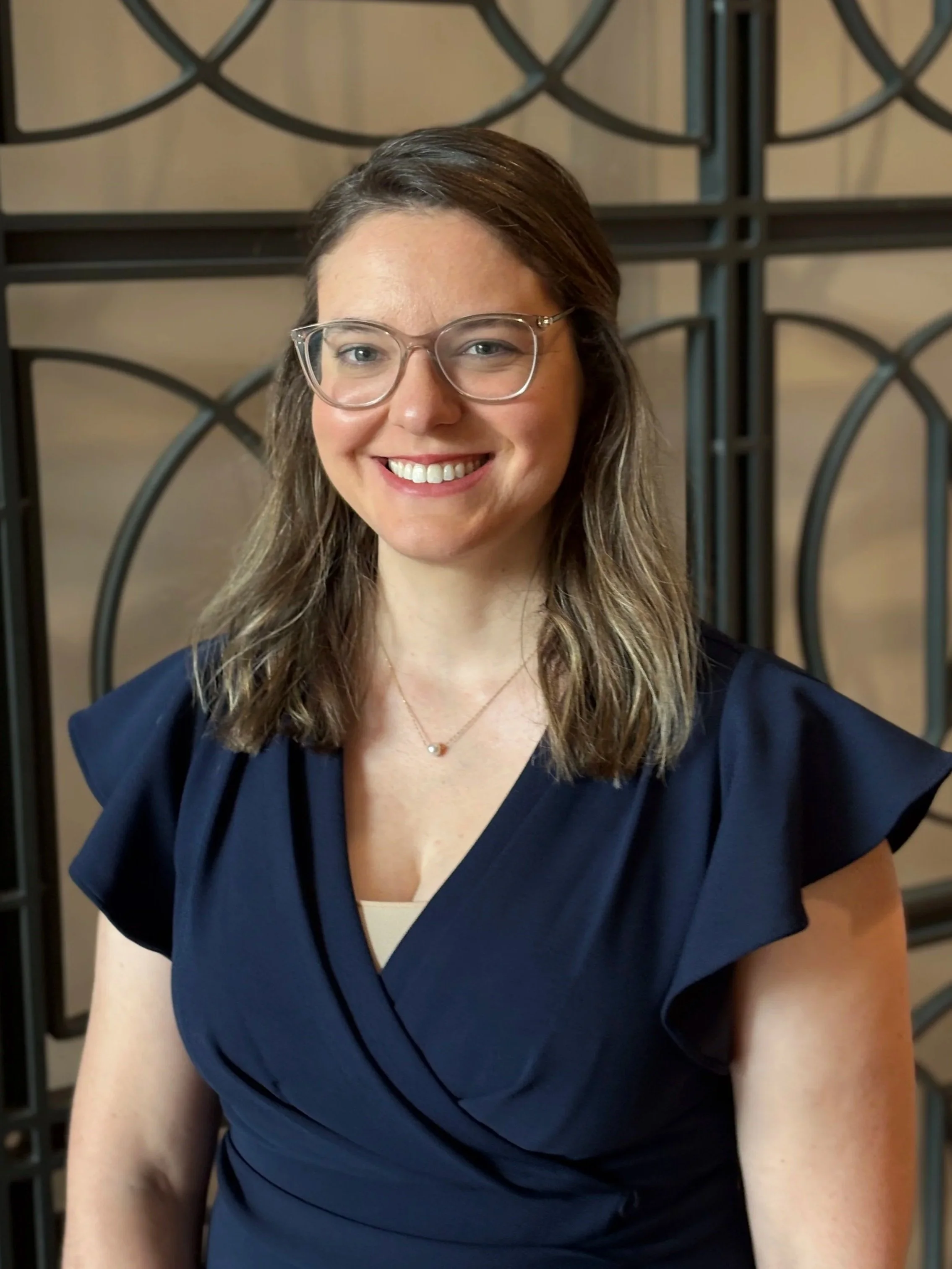 woman in glasses wearing navy dress