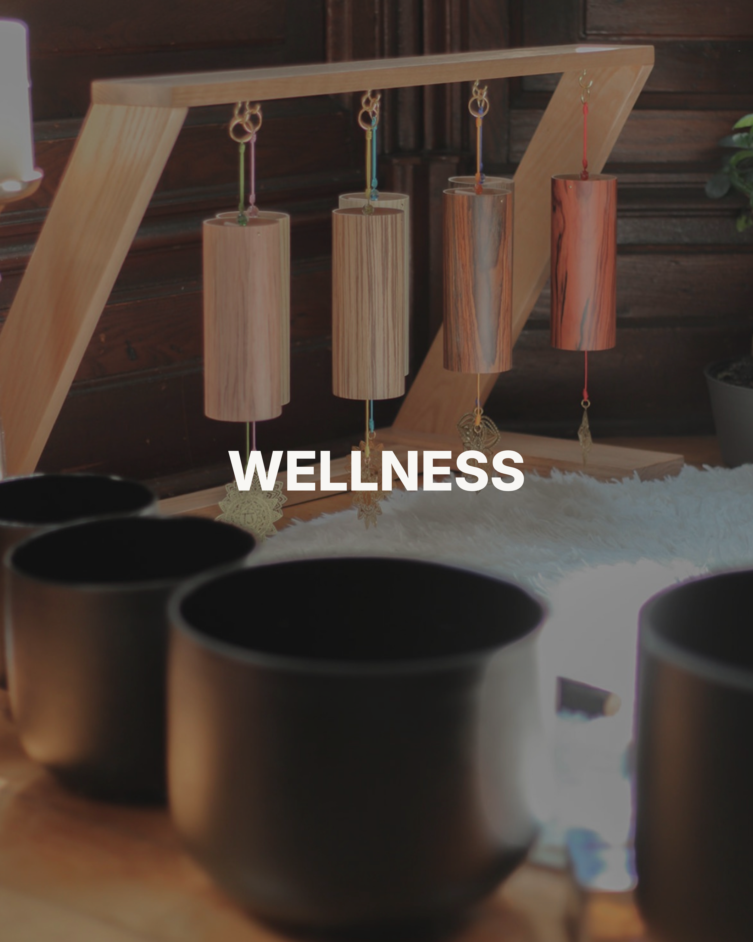 Close-up of several black coffee mugs on a wooden table, with a blurred background showing a wooden wall.
