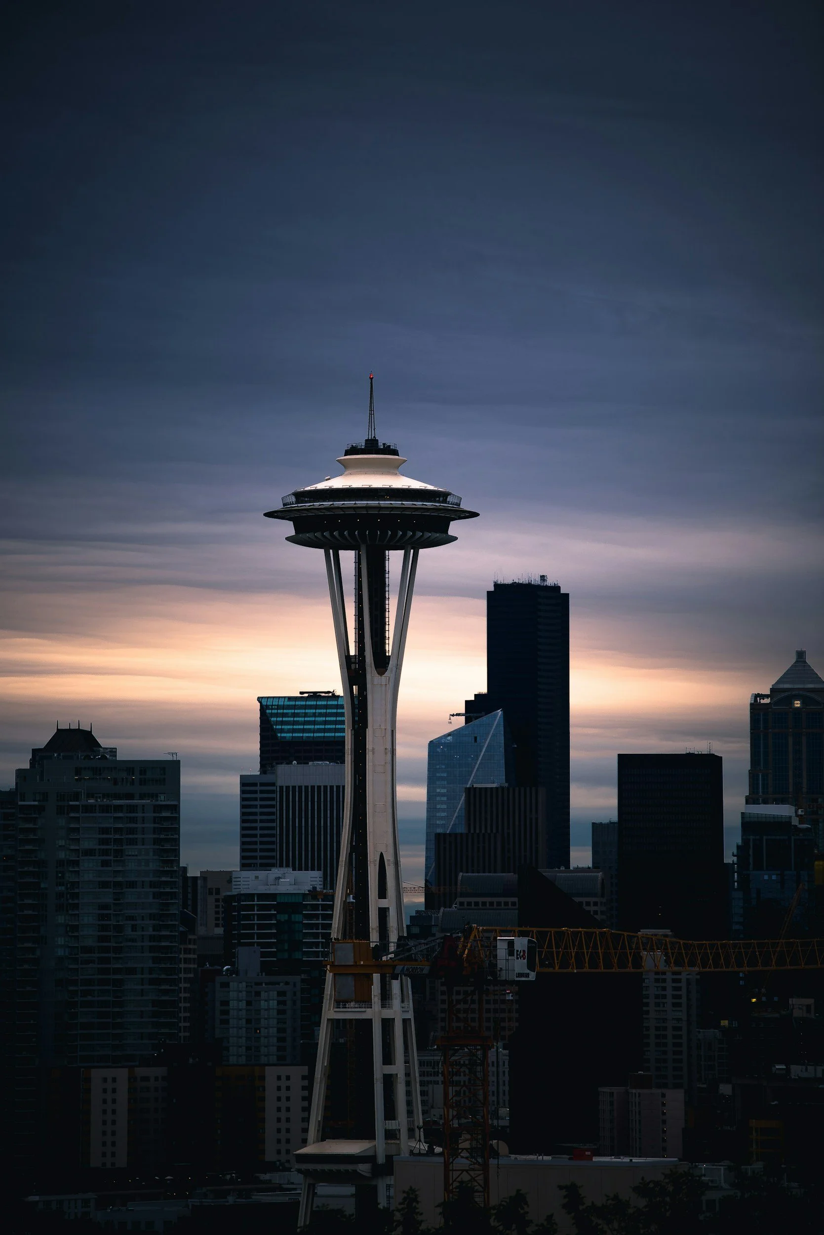 Seattle skyline at dusk with Space Needle in the foreground and dark sky in the background.