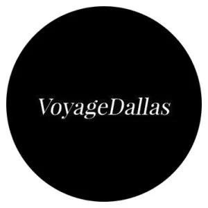 Black circular logo with white text that reads 'Voyage Dallas'
