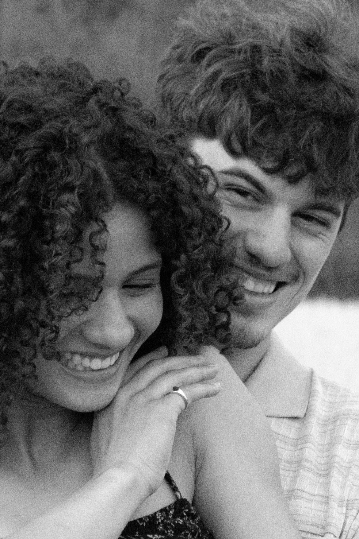 A black and white photo of a happy couple smiling and close together. Couple photography, engagements