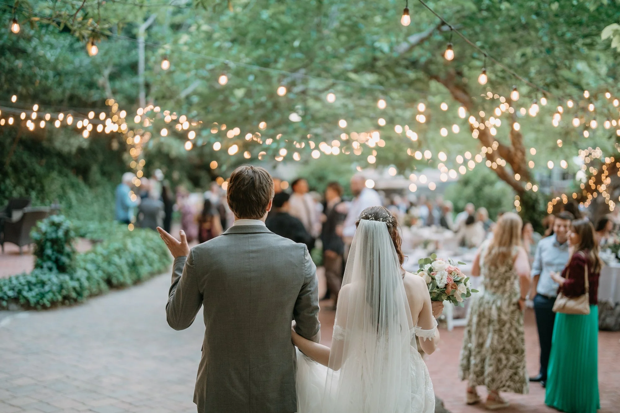 Newlyweds walking into their reception under string lights at Wildwood Acres, Lafayette CA