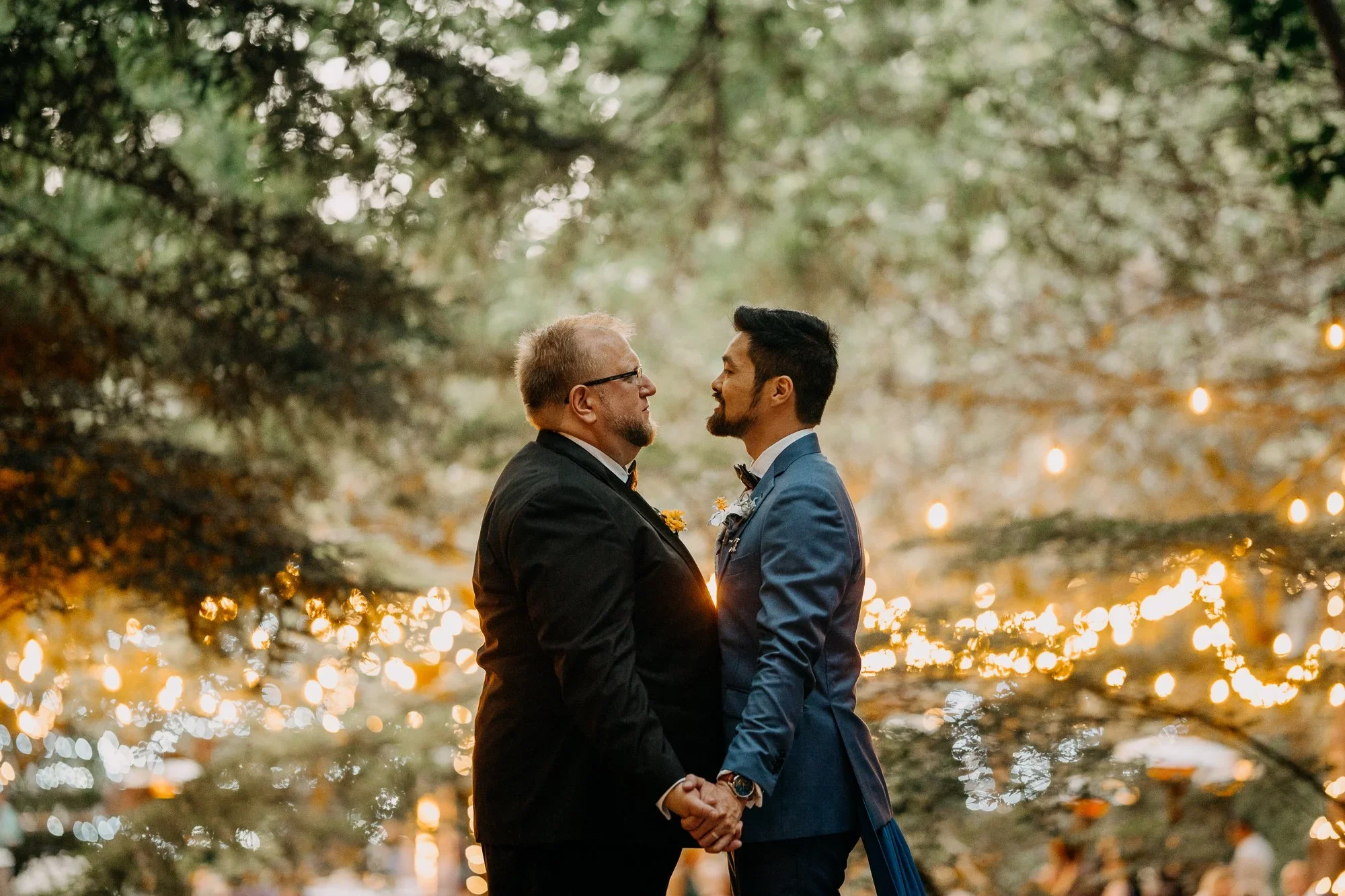 Grooms celebrating under twinkling lights