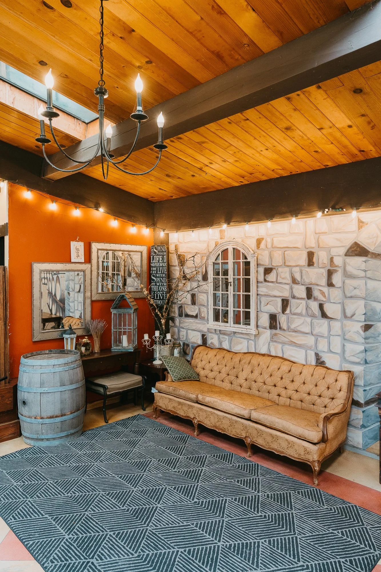 Cozy clubhouse lounge with vintage sofa and string lights at Wildwood Acres