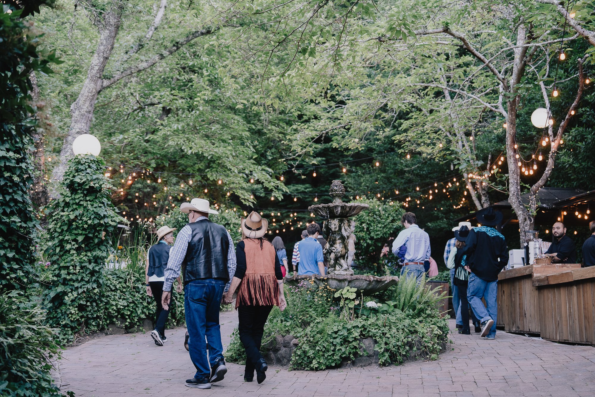 Guests strolling the garden grounds under the oaks at Wildwood Acres