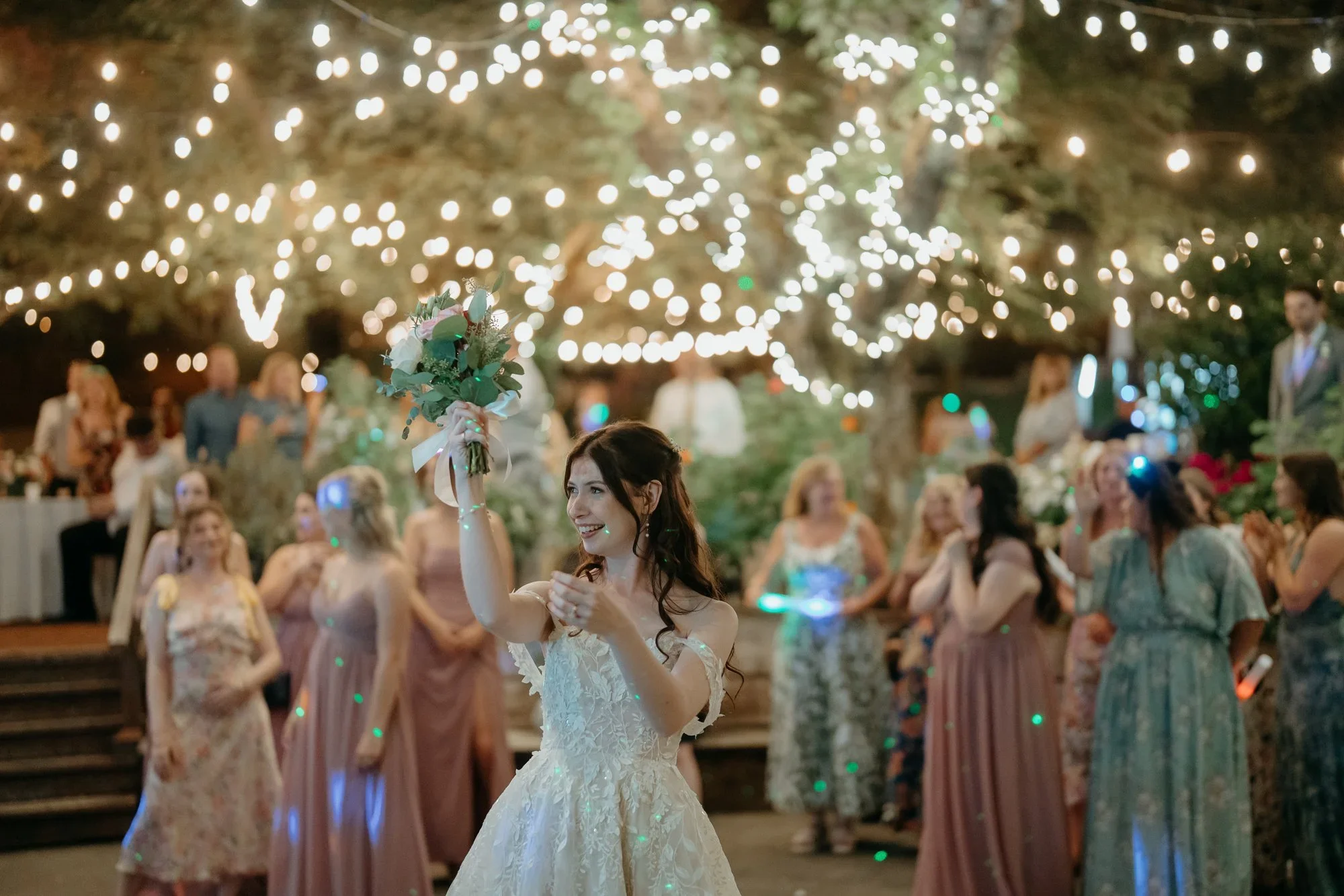 Wedding party celebrating under string lights