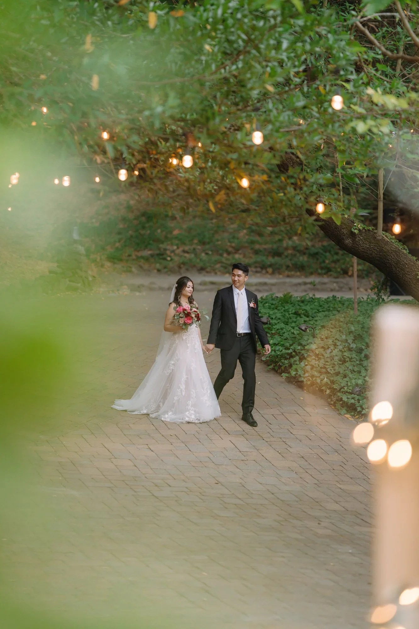 Bride and groom walking through the garden