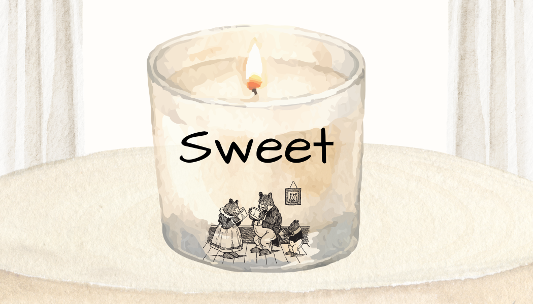 A lit candle in a glass holder labeled 'Sweet' with a bear family illustration at the bottom, placed on a surface near a window.