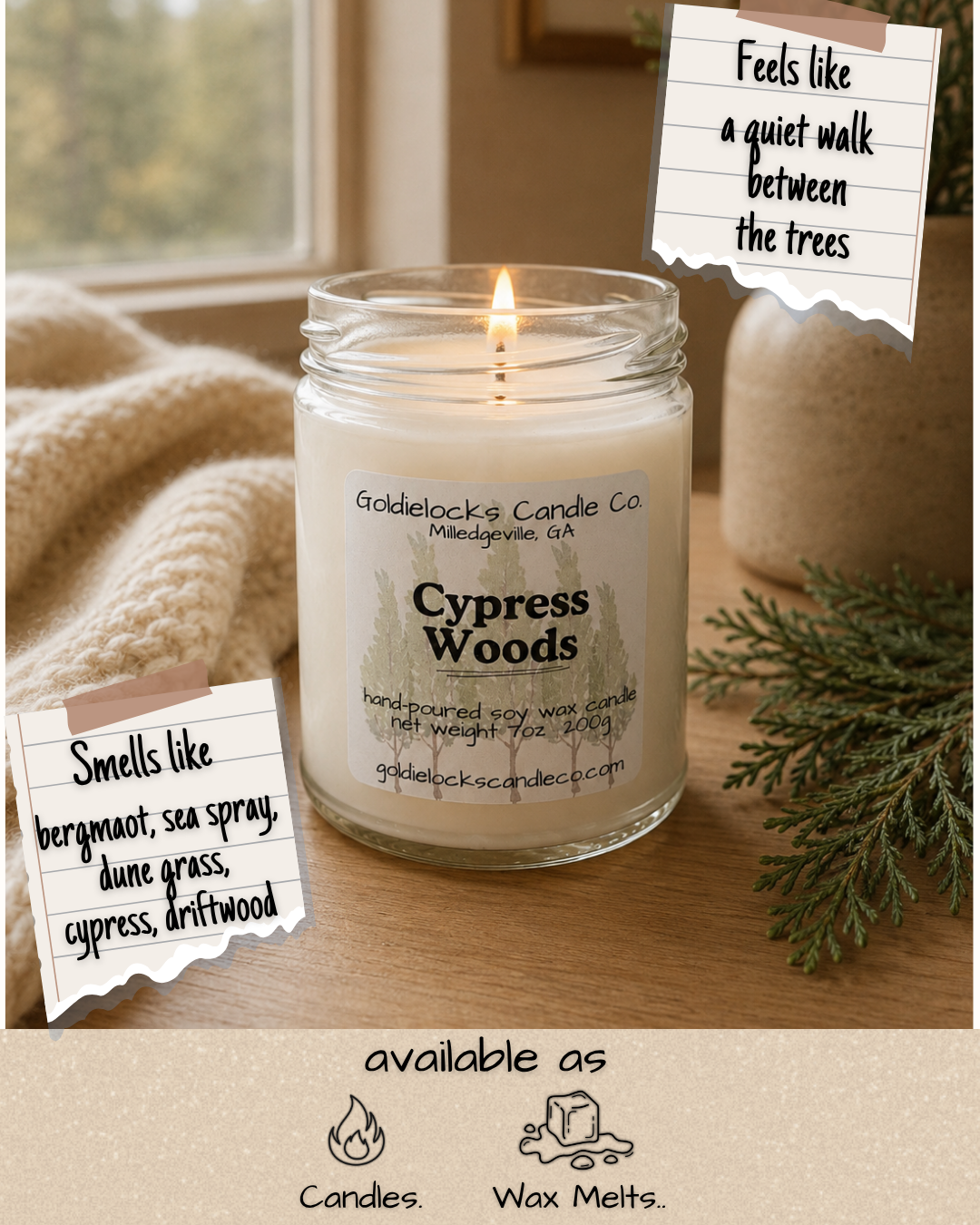 A lit candle in a glass jar labeled 'Cypress Woods' from Goldielocks Candle Co., sitting on a wooden surface with a background of a window, a beige knitted blanket, and greenery. There are handwritten notes indicating it 'feels like a quiet walk between the trees' and 'smells like bergamot, sea spray, dune grass, cypress, driftwood.' Icons and text at the bottom indicate the candle is available as candles and wax melts.