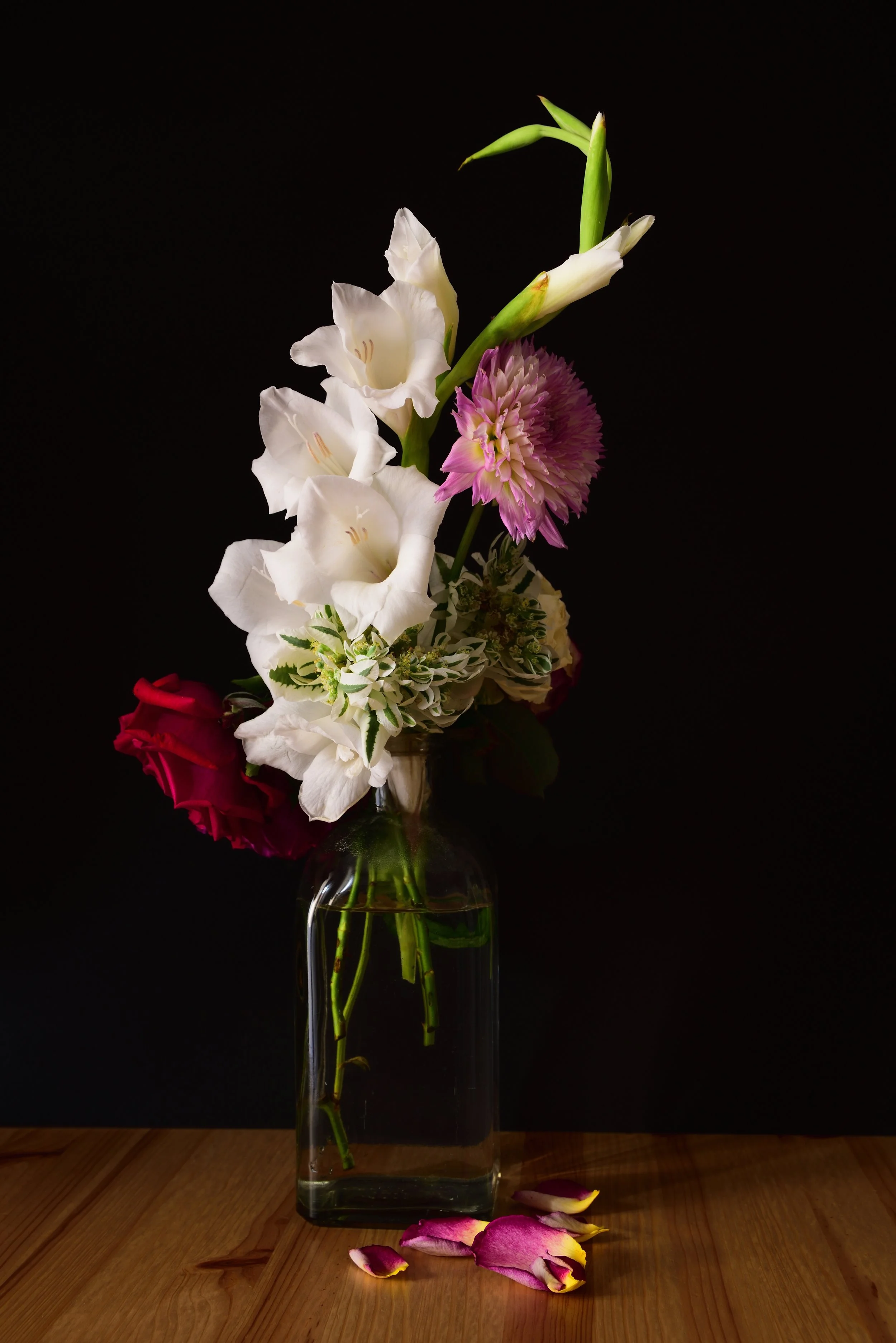vertical_shot_different_flowers_jar_wooden_surface_with_black_background.jpg