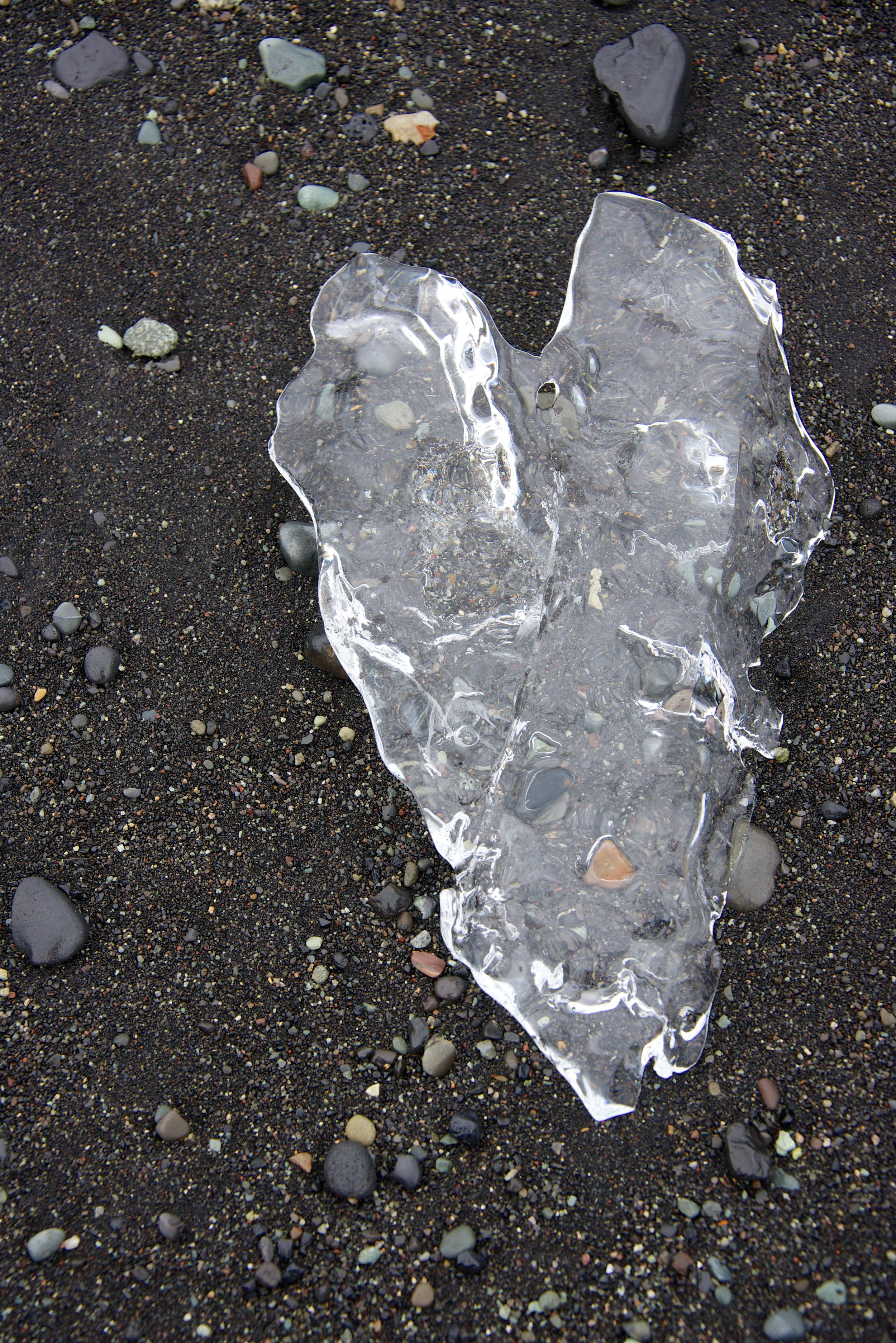 heart made of ice on black sandy beach