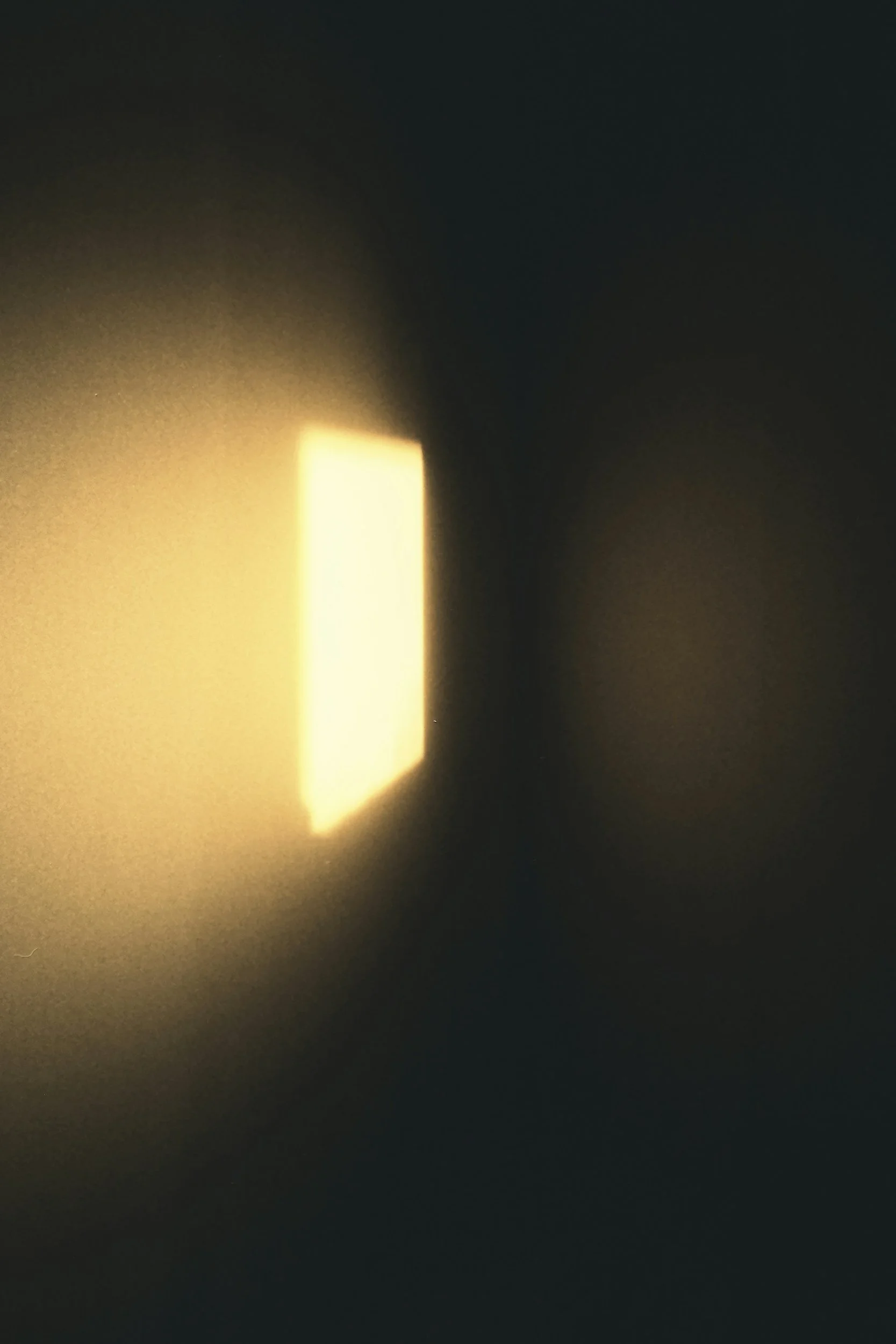 A square-shaped light visible through a dark environment, creating a glowing effect.