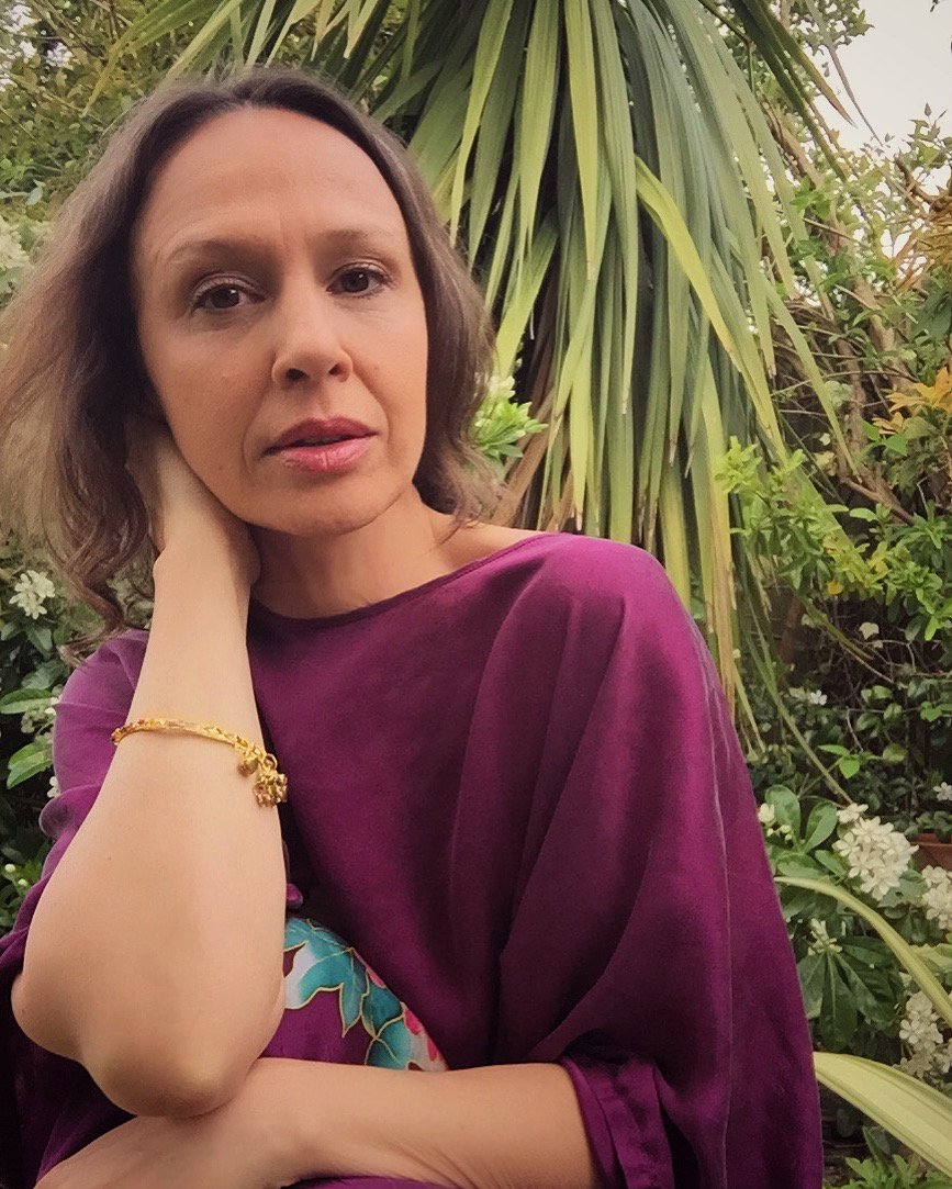 Portrait of mixed media artist Stephanie Hymas in a garden setting.