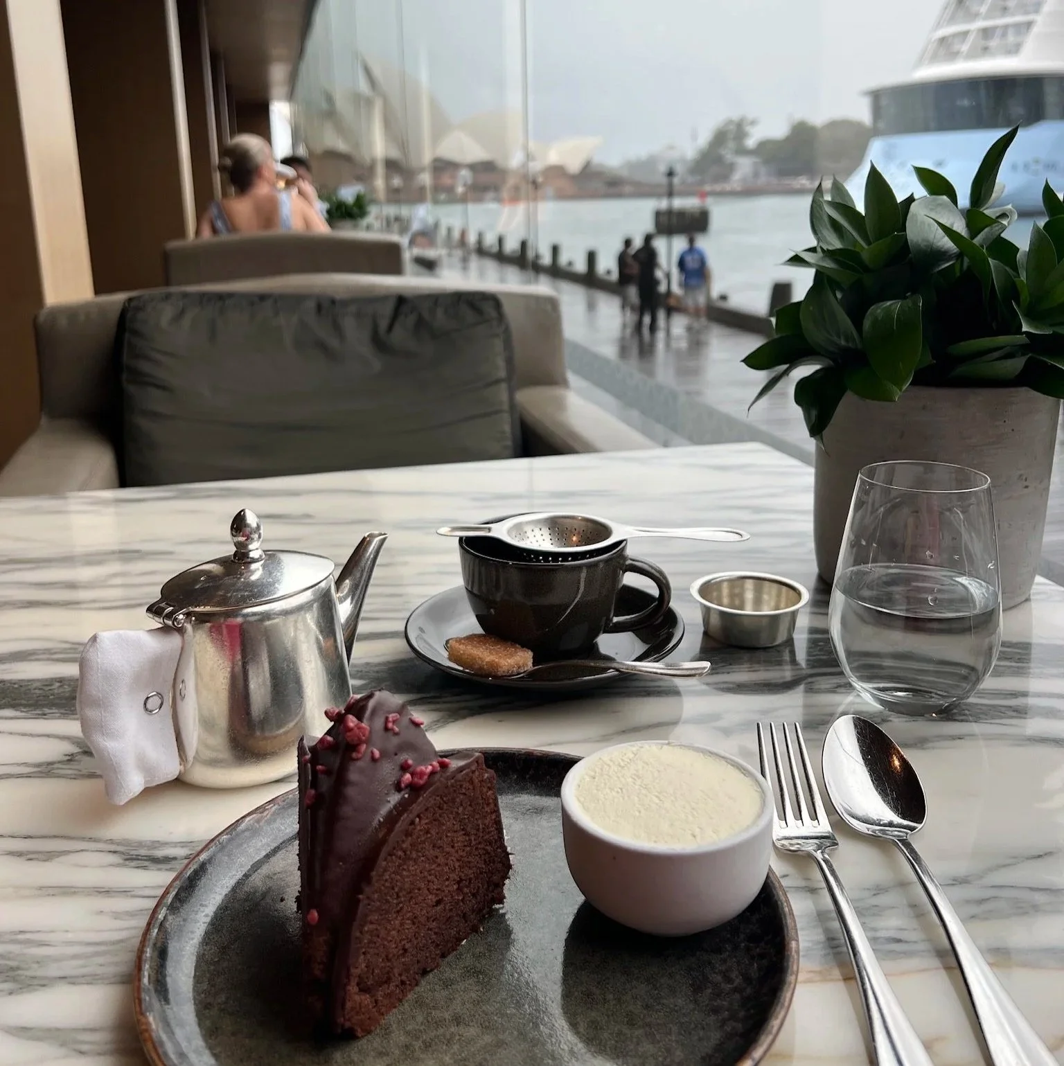 Living Room Park Hyatt Sydney chocolate cake and tea with cream on a rainy day with the Sydney Opera House in the background.