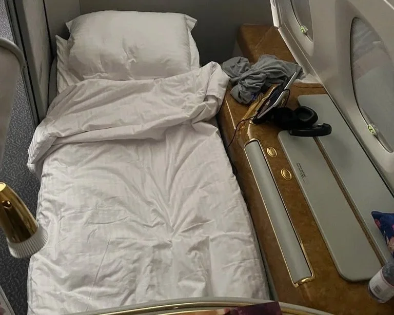 Emirates first-class lie flat bed with duvet and pillow.