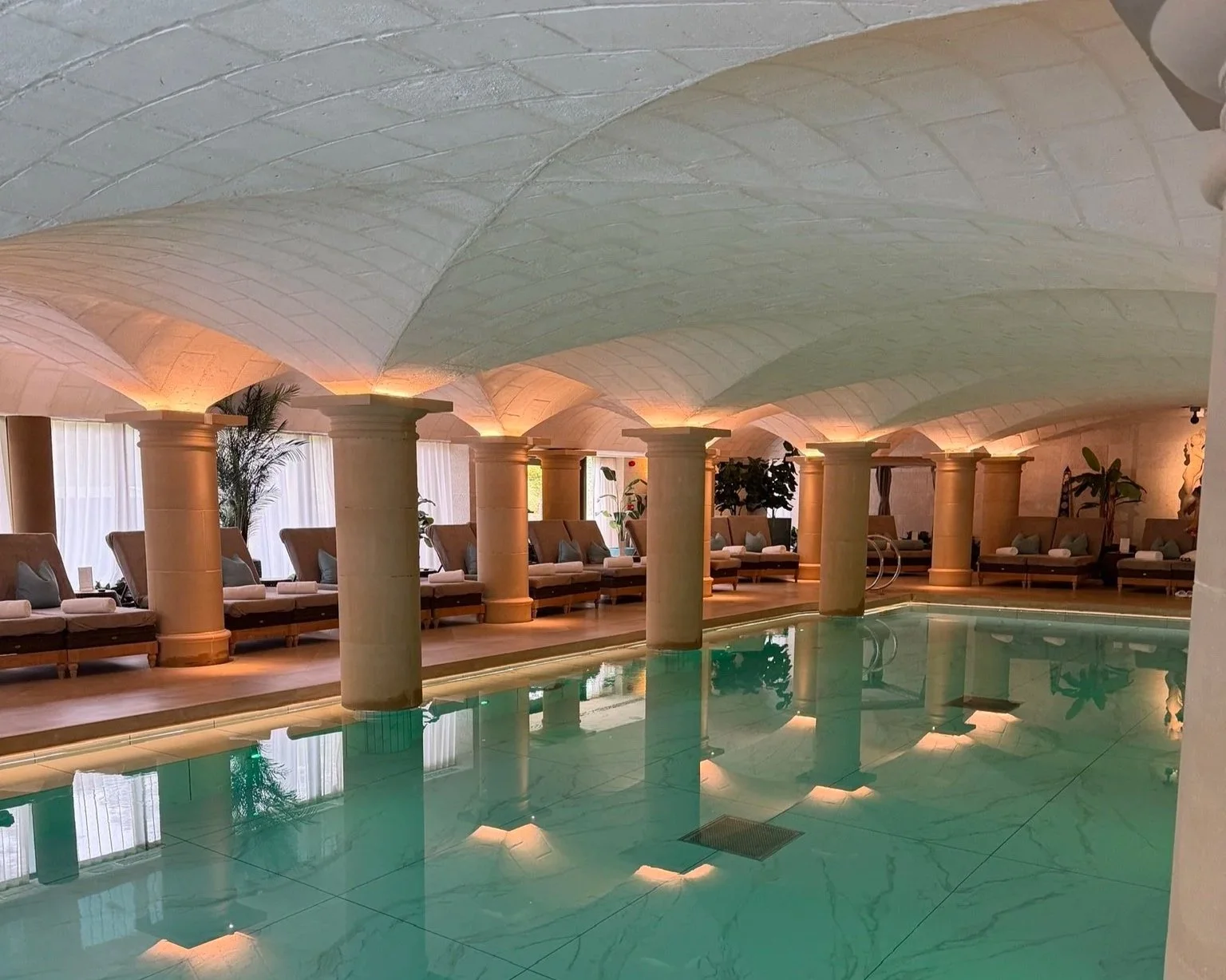 Grantley Hall Three Graces Spa swimming pool with Roman-style pillars and lights.