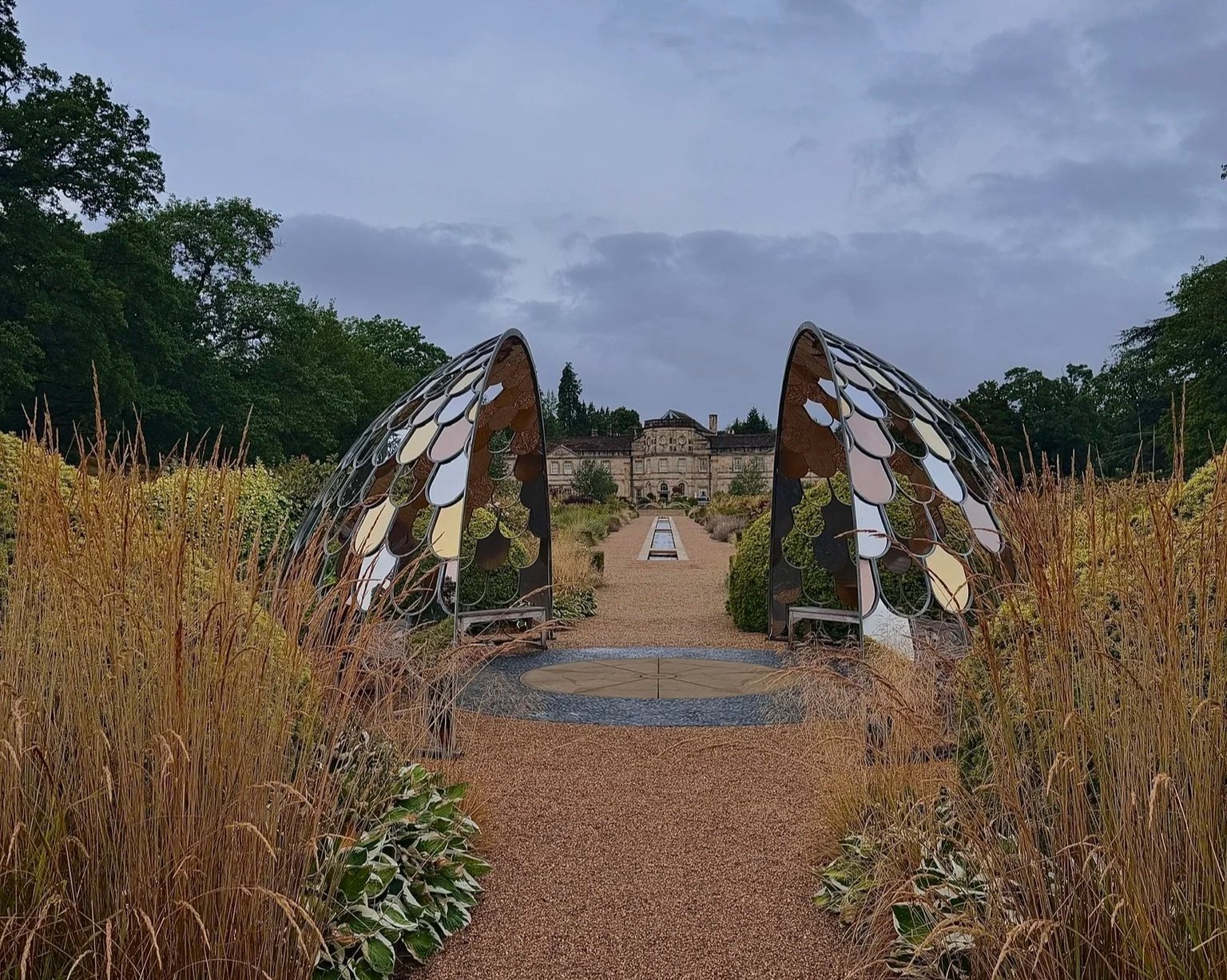 Grantley Hall Rill Garden looking towards the hall through the metal, mirrored split dome down long the water feature.