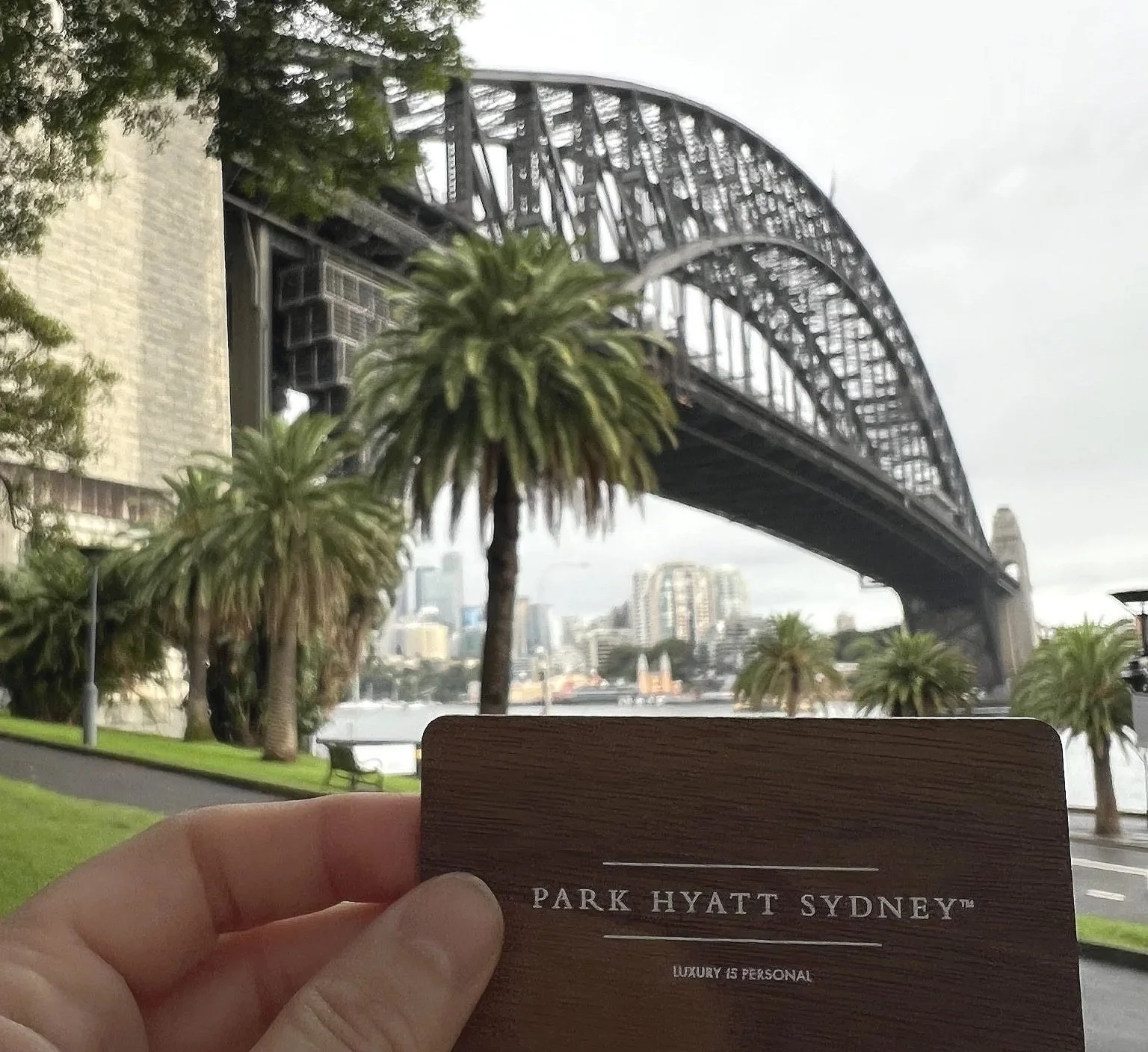 Park Hyatt Sydney room card in front of Sydney Harbour Bridge with trees to the left hand side.