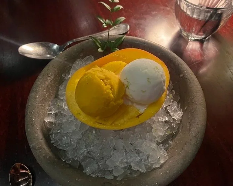 Raffles The Palm Matagi Japanese restaurant mango and coconut ice cream balls on a mango shell on a bowl with ice.