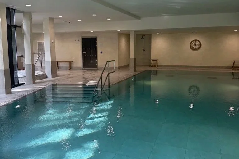 Swimming pool with jacuzzi in the far left corner.