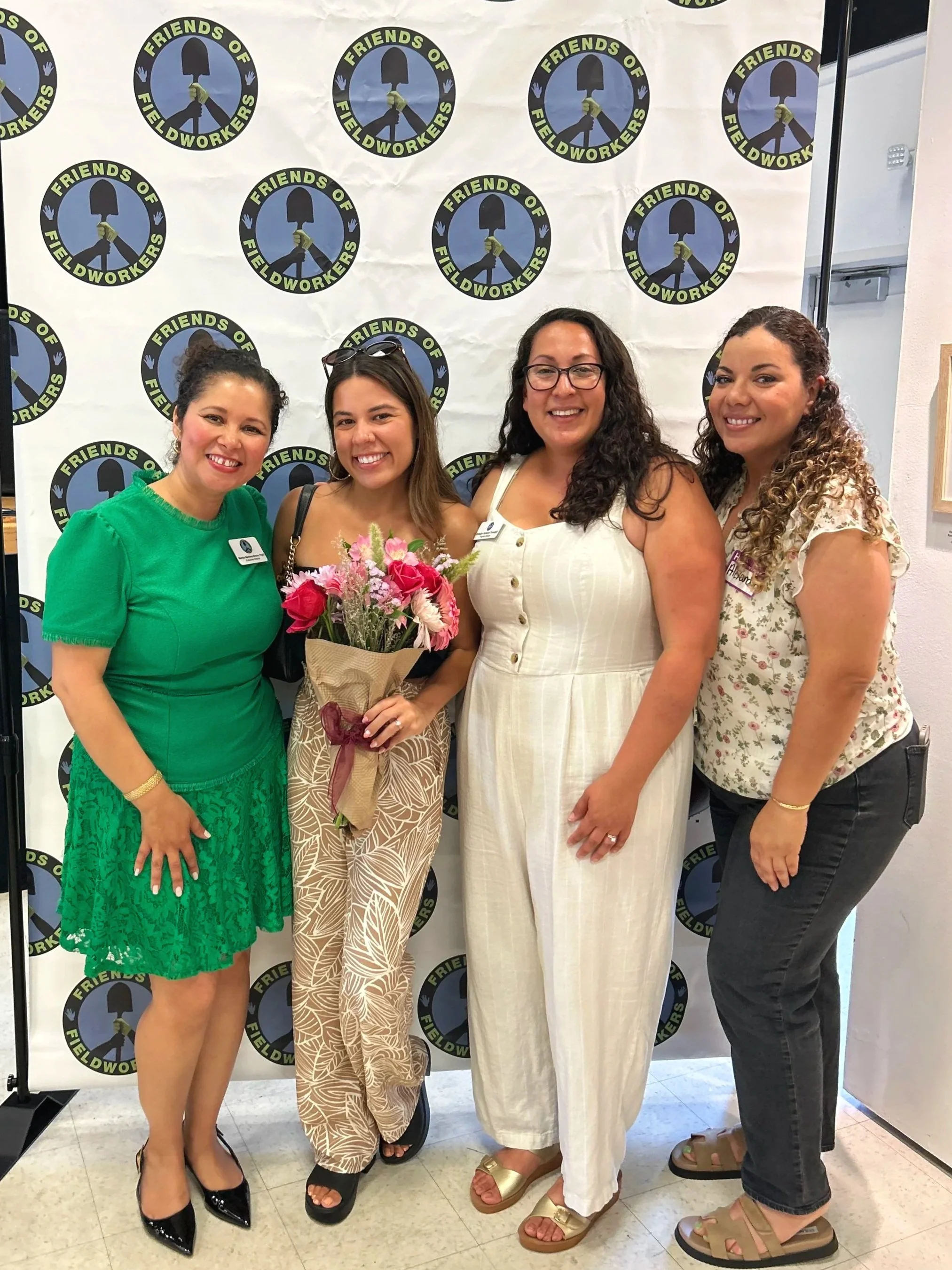 Four women standing in front of a backdrop with the 