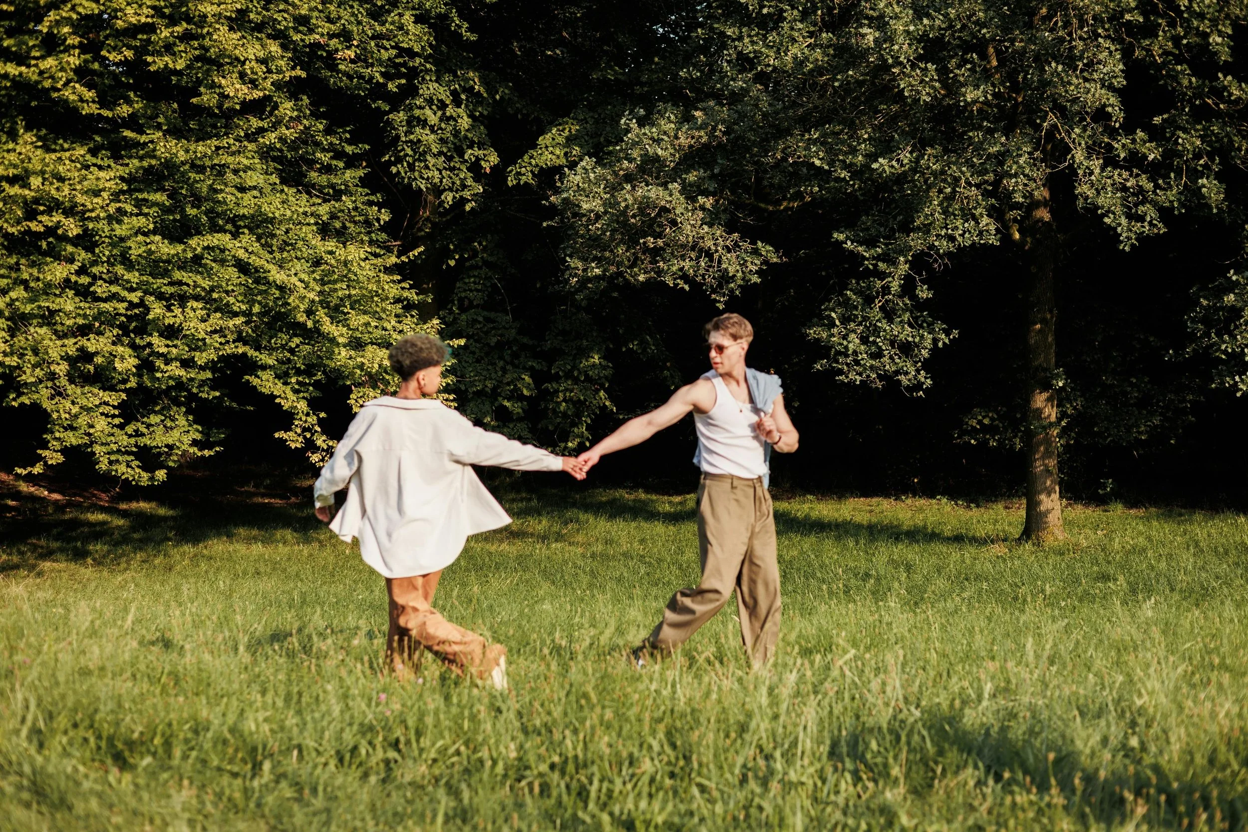 Couple holding hands in field representing intercultural relationship therapy at Intentional Therapy