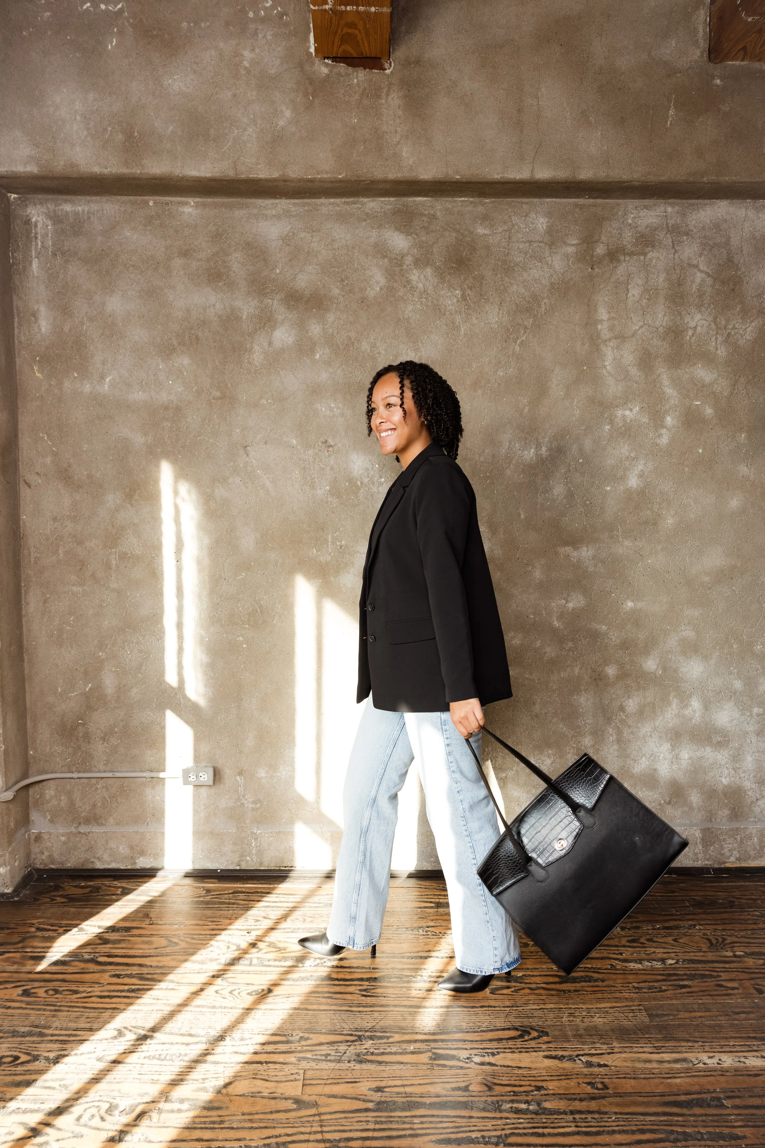 Ayesha Youngblood walking with a professional tote bag