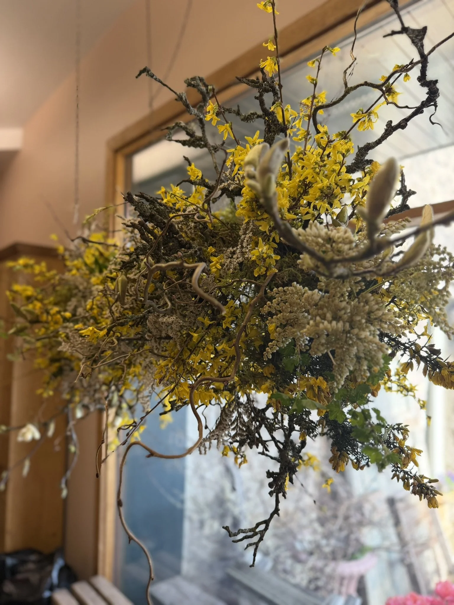 A hanging cloud floral installation featuring yellow forsythia.