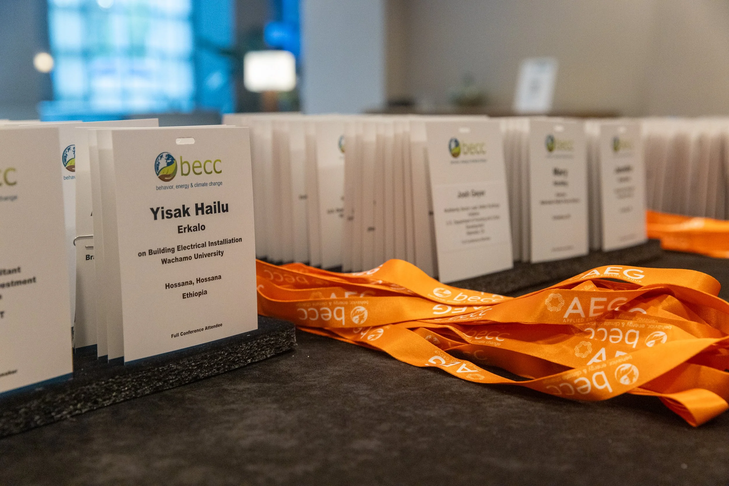 Conference name tags and orange lanyards for attendees at a professional event, with the logo of BECC and AECC