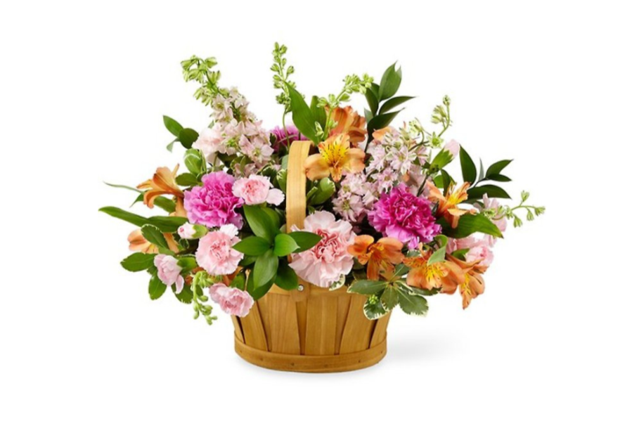 A basket filled with pink and orange flowers with green leaves.