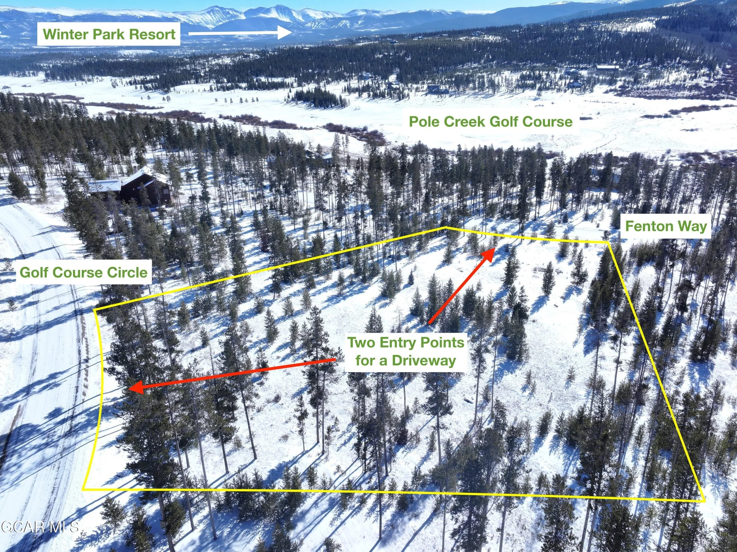 An aerial view of a snowy landscape with labeled features including a forested area, a golf course circle, two entry points for a driveway marked with arrows, a road, and distant mountains, with a snow-covered golf course and a few buildings visible 